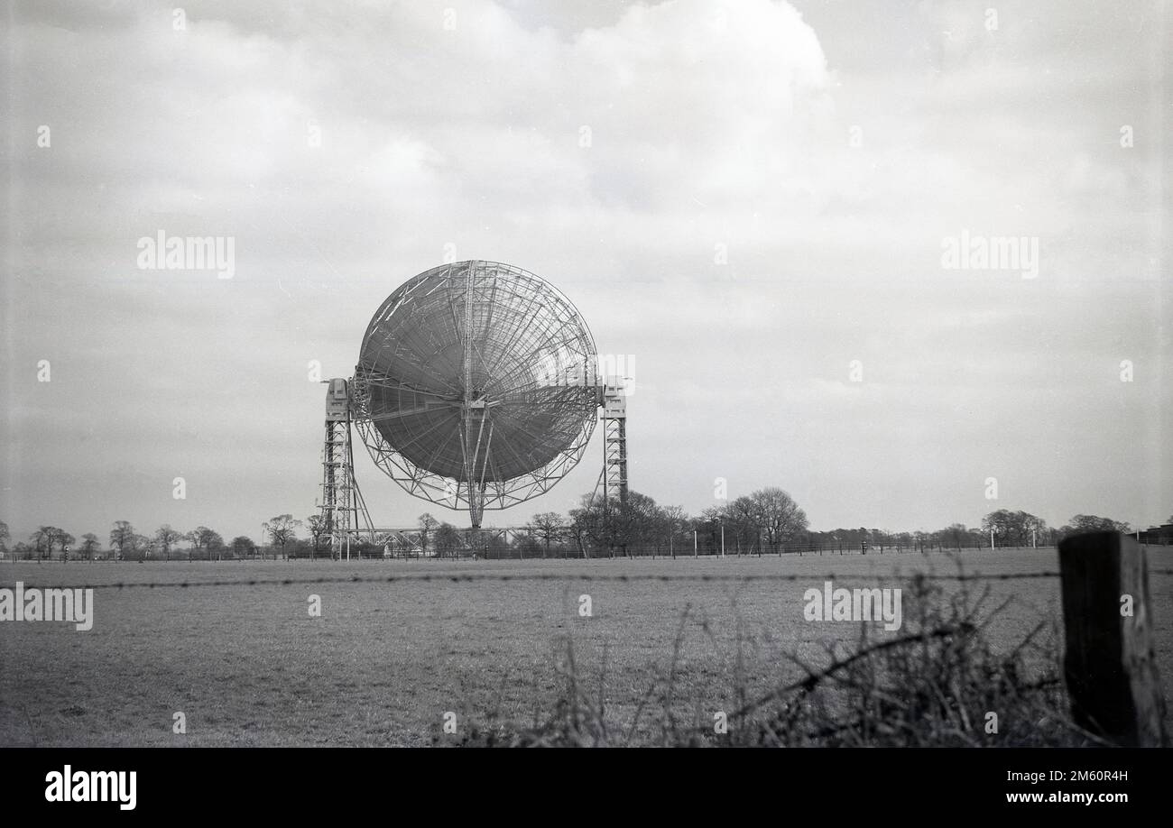 Ende 1950er, ein historischer Blick auf das Mark i oder Lovell Teleskop, Cheshire, England, Großbritannien, das größte Radio-Teleskop der Welt, als es 1957 gebaut wurde. Das Radioteleskop ist nach Bernard Lovell benannt, einem Radioastronomen an der Manchester University, der 1945 in Nordwestengland ein Observatorium - das Jodrell Bank Observatory - errichtete, um kosmische Strahlen zu untersuchen und seine Arbeit auf Radar während des Zweiten Weltkriegs fortzusetzen. 1988 wurde das Lovell Telescope zum denkmalgeschützten Gebäude der Kategorie I gemacht, was bedeutet, dass es ein Gebäude von „außergewöhnlichem Interesse“ ist. Stockfoto
