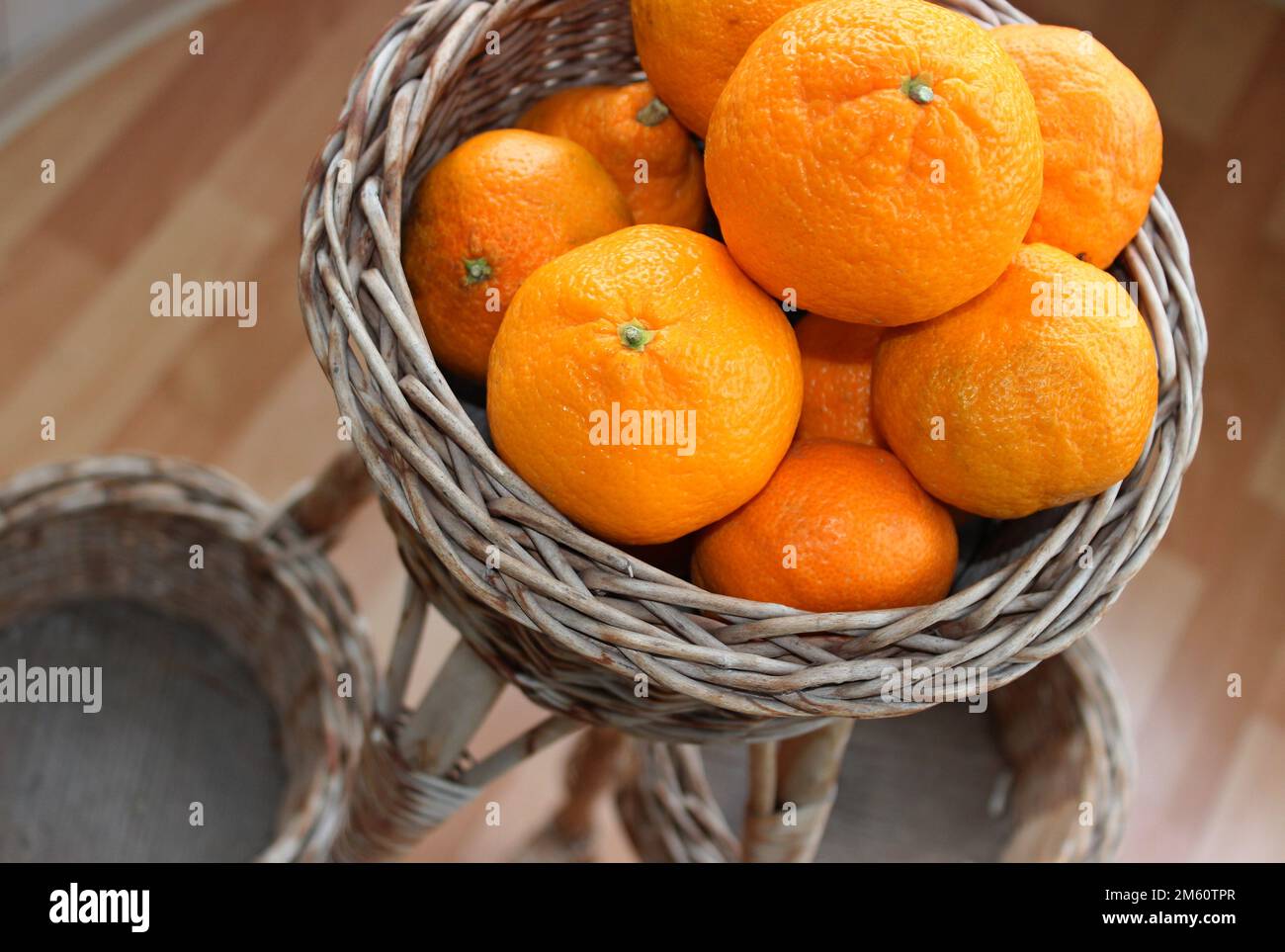 Ganze Mandarinen-Früchte in Einem Korb mit Rattan Rack Top View Stockfoto