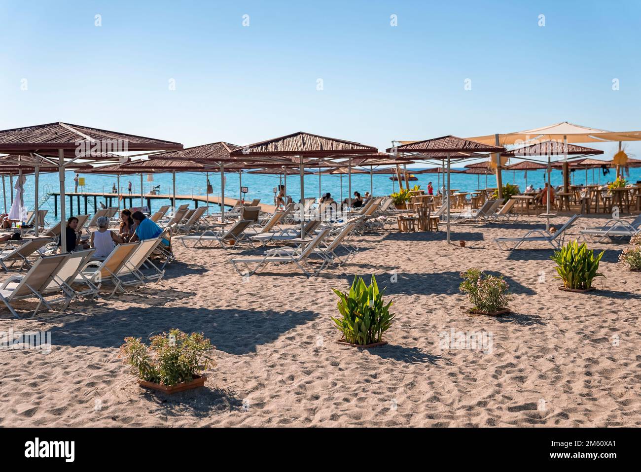 Liegestühle und Sonnenschirme am Sandstrand bei sonnigen Tagen Stockfoto
