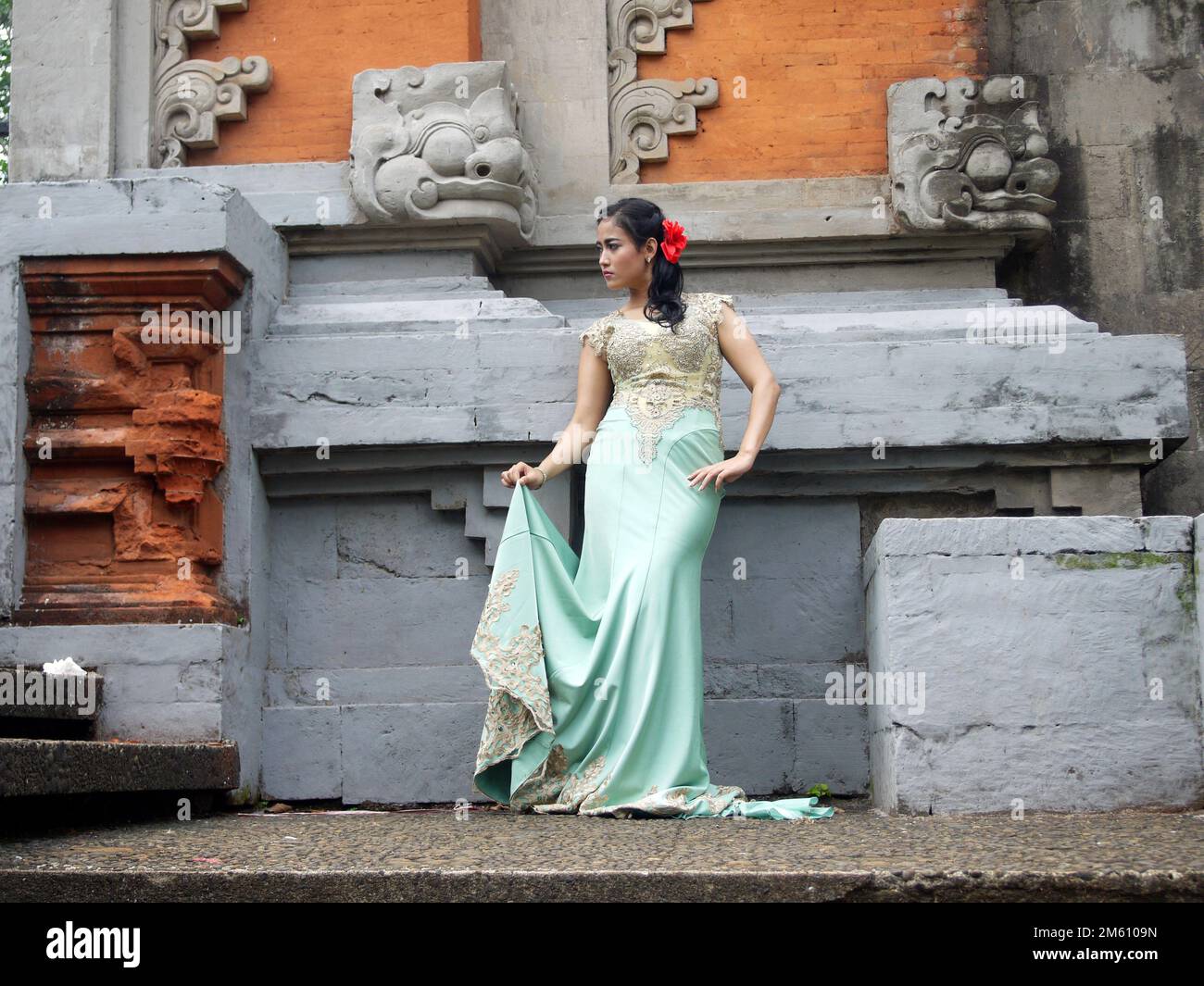 Porträt einer balinesischen Frau in traditioneller balinesischer Mode mit Blumendekorationen auf ihrem Haar Stockfoto