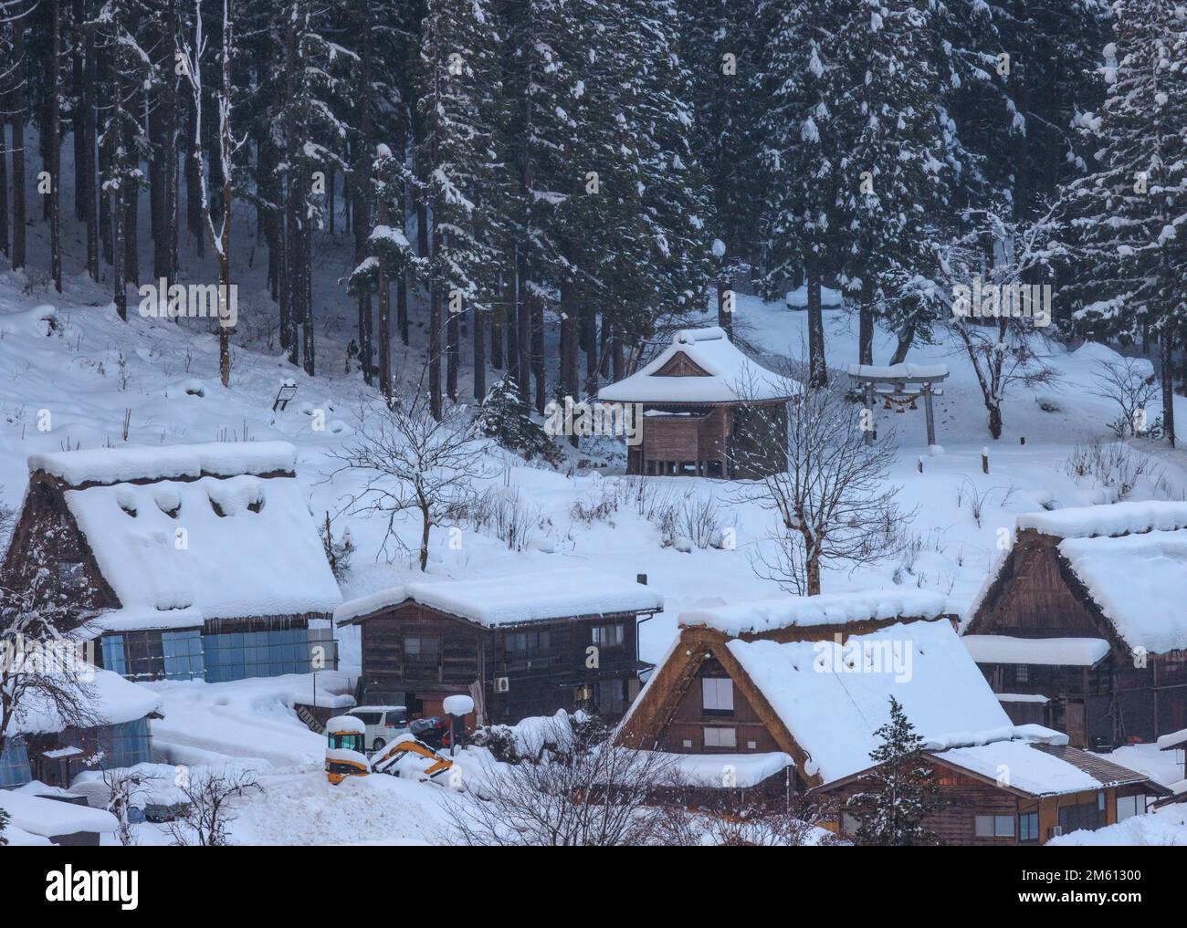 Steile Dächer mit Schnee bedeckt in Bergdorf mit Wäldern Stockfoto