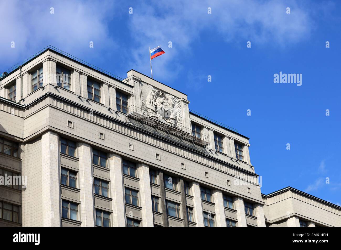 Russische Flagge auf dem Parlamentsgebäude in Moskau gegen blauen Himmel mit Wolken. Staatsduma von Russland Stockfoto
