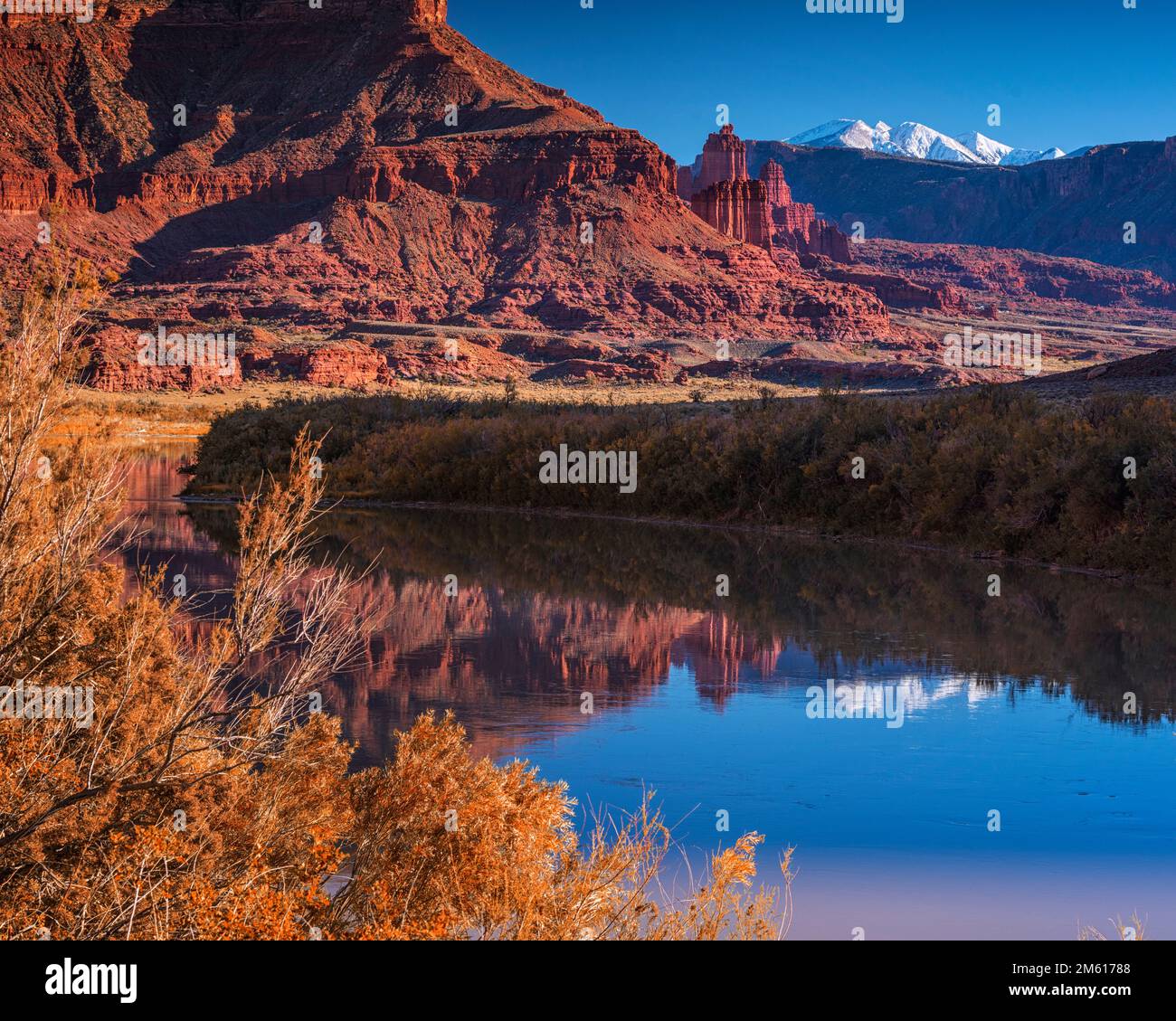 Unberührte Reflexion der Fishers Towers und der schneebedeckten La Sal Berge im Colorado River bei Moab, Utah Stockfoto