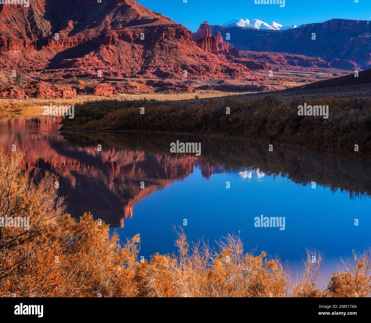 Unberührte Reflexion der Fishers Towers und der schneebedeckten La Sal Berge im Colorado River bei Moab, Utah Stockfoto