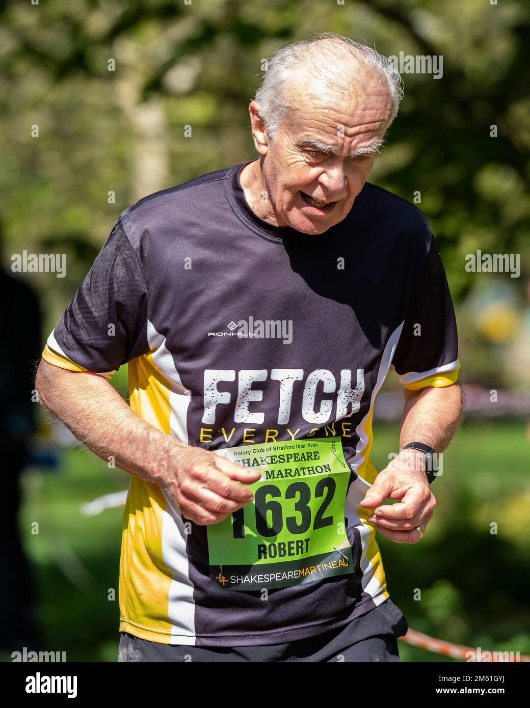 Ein kräftiger alter Mann, der bei einem Halbmarathon antritt. Stockfoto