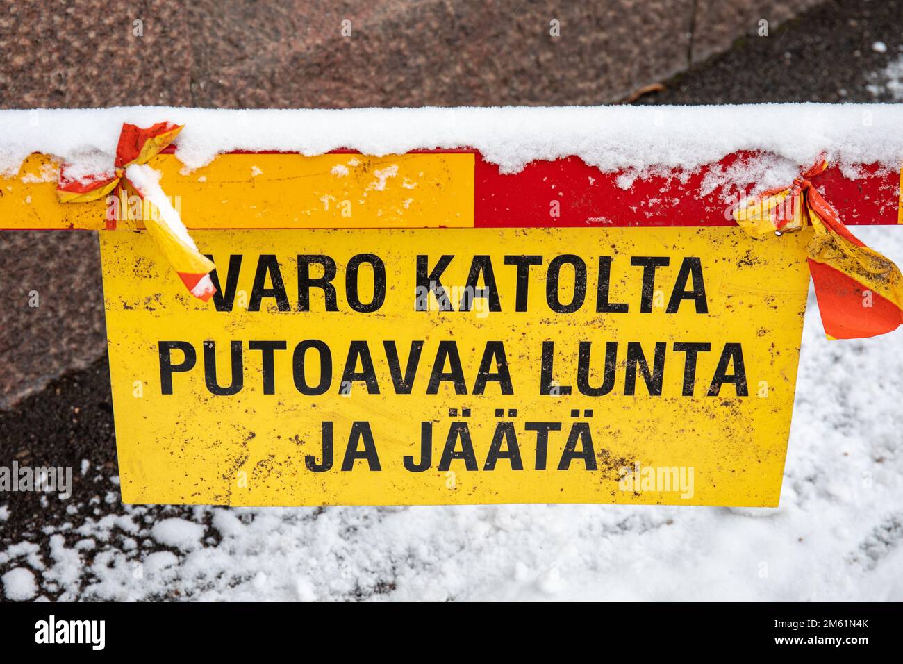 Varo katolta putoavaa lunta ja jäästi. Vorsicht vor herabfallendem Schnee und Eis. Gelbes Warnschild in Helsinki, Finnland. Stockfoto