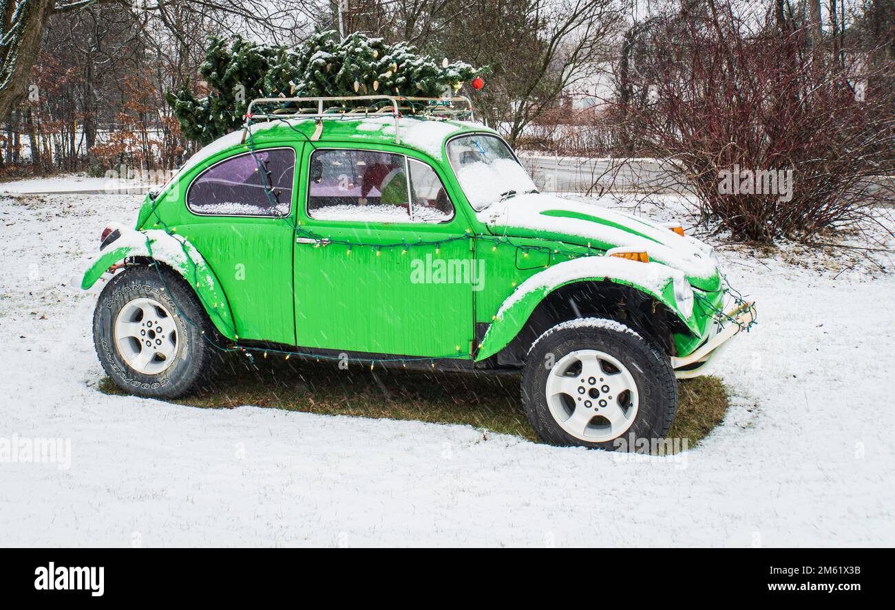 Hellgrüner VW Bug mit Weihnachtsbaum und Lichtern für die Feiertage Stockfoto