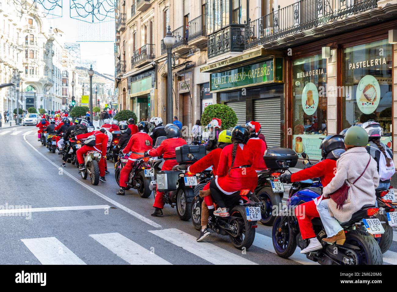 Granada, Spanien; 18. Dezember 2022: Zu Weihnachten fahren als Weihnachtsmann verkleidete Menschen mit ihren Motorrädern durch eine Straße im Zentrum von Granada Stockfoto