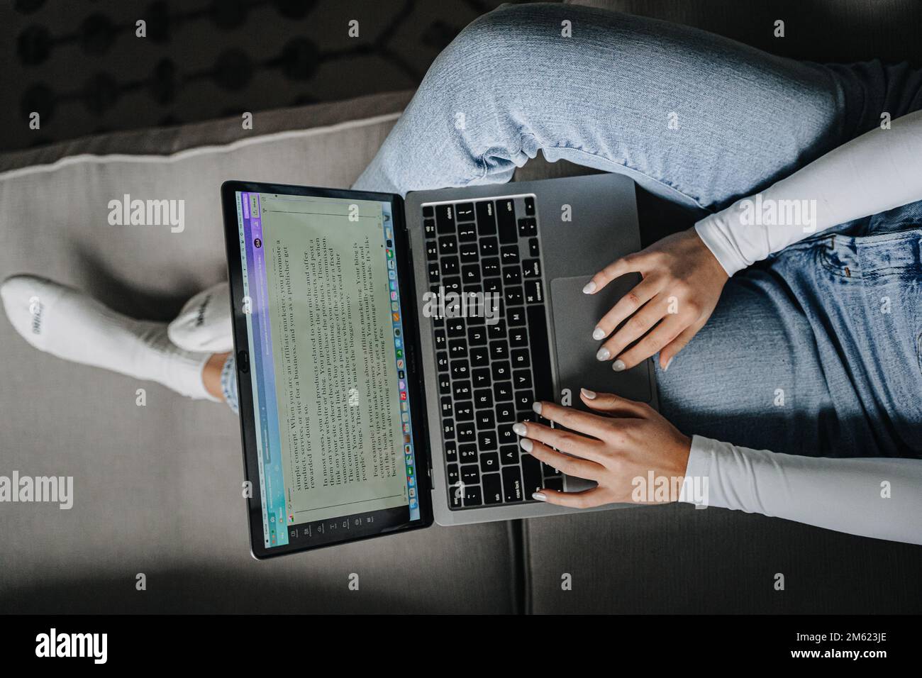 Mädchen, das von zu Hause aus an einem Laptop arbeitet Stockfoto