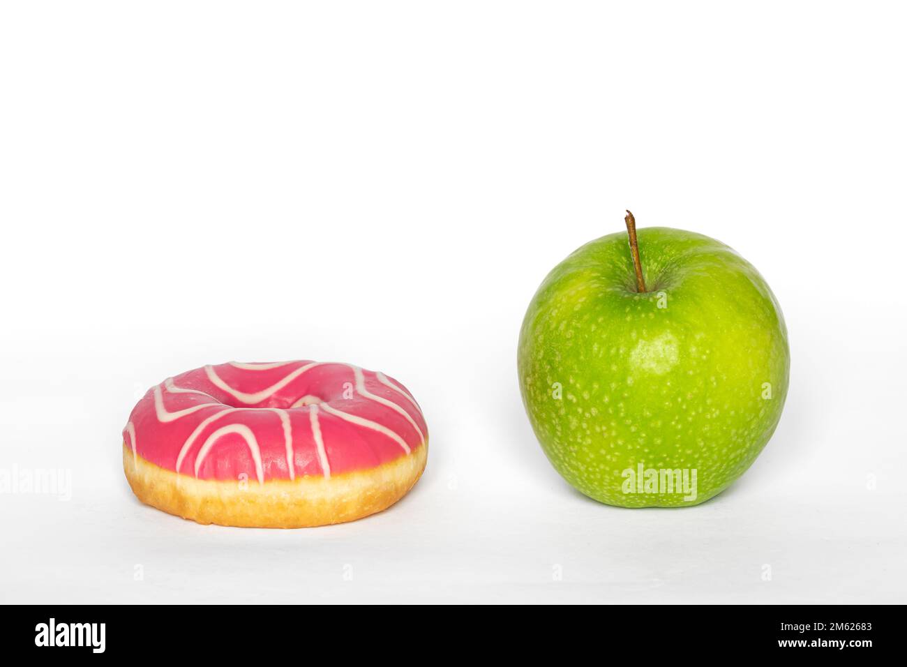 Rosa Donut und Apfel, gesunde Ernährung und Diät Konzept. Stockfoto