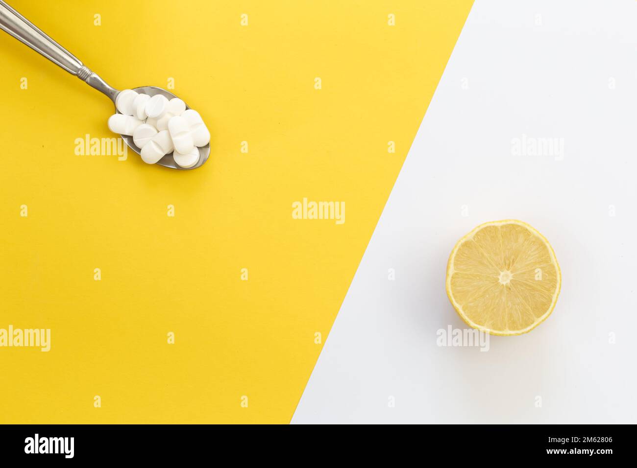 Pillen und Zitrone auf gelbem Hintergrund, flach liegend. Stockfoto