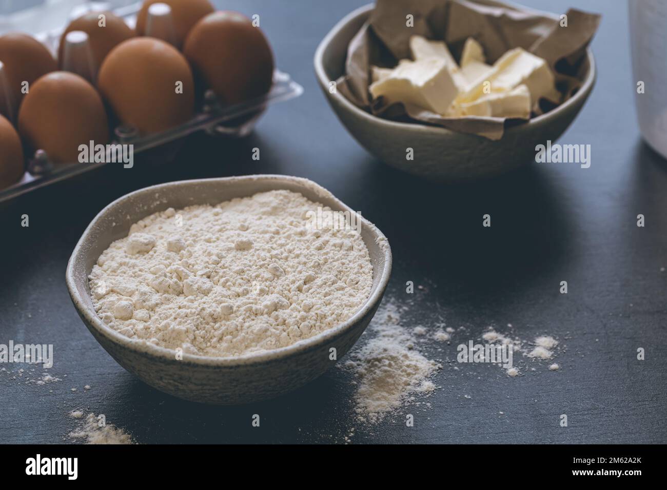 Mehl, Butter und Eier auf dem Küchentisch, Nahaufnahme. Stockfoto