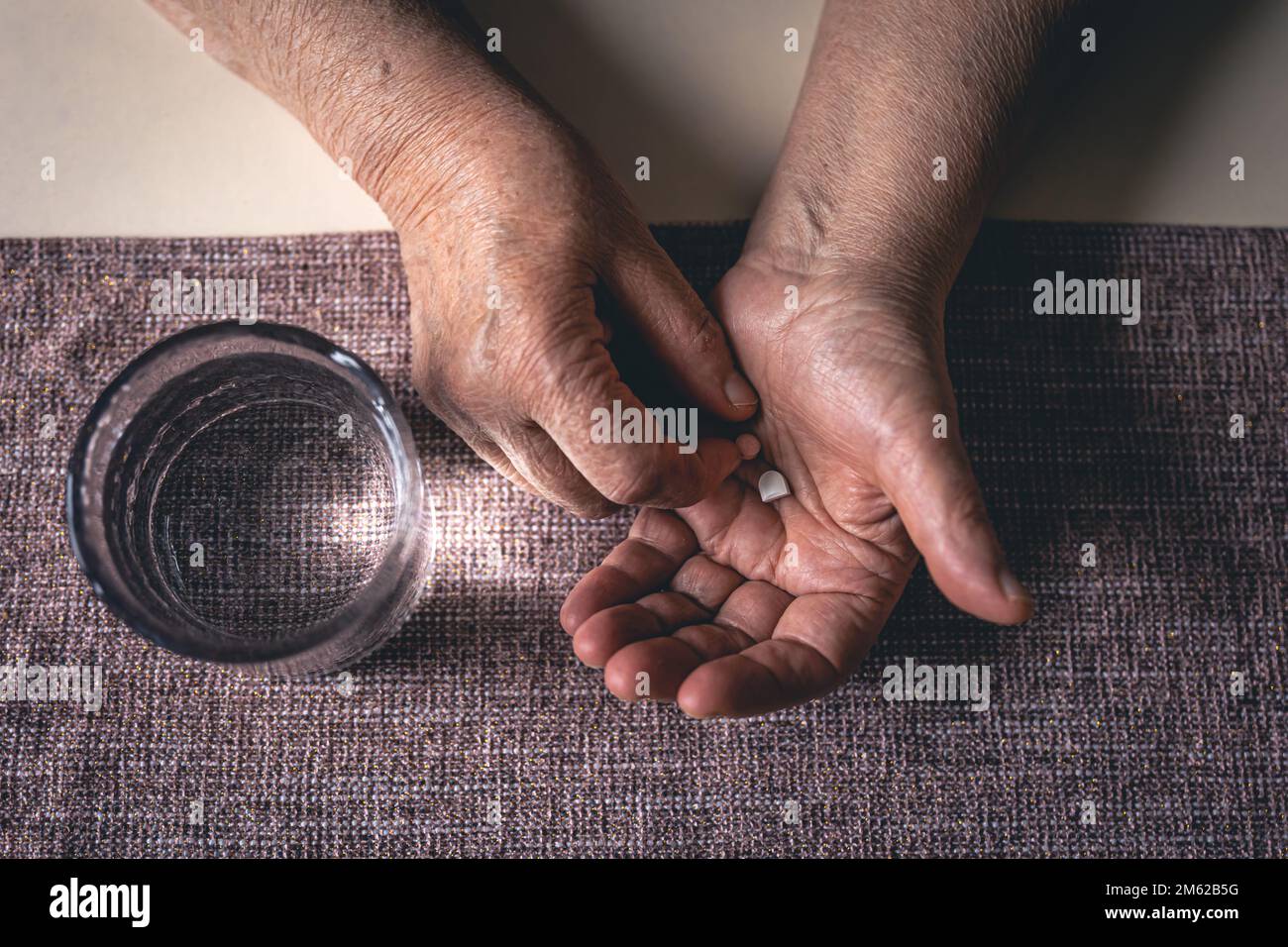 Pillen in den Händen einer alten Frau, Draufsicht. Stockfoto