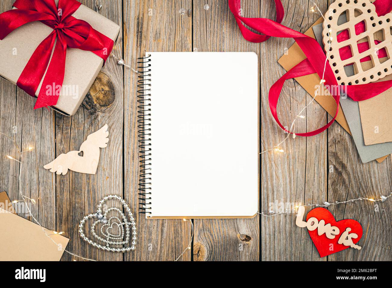 Ein leeres Notizbuch auf Holzhintergrund, Valentinstag-Konzept, flach liegend. Stockfoto