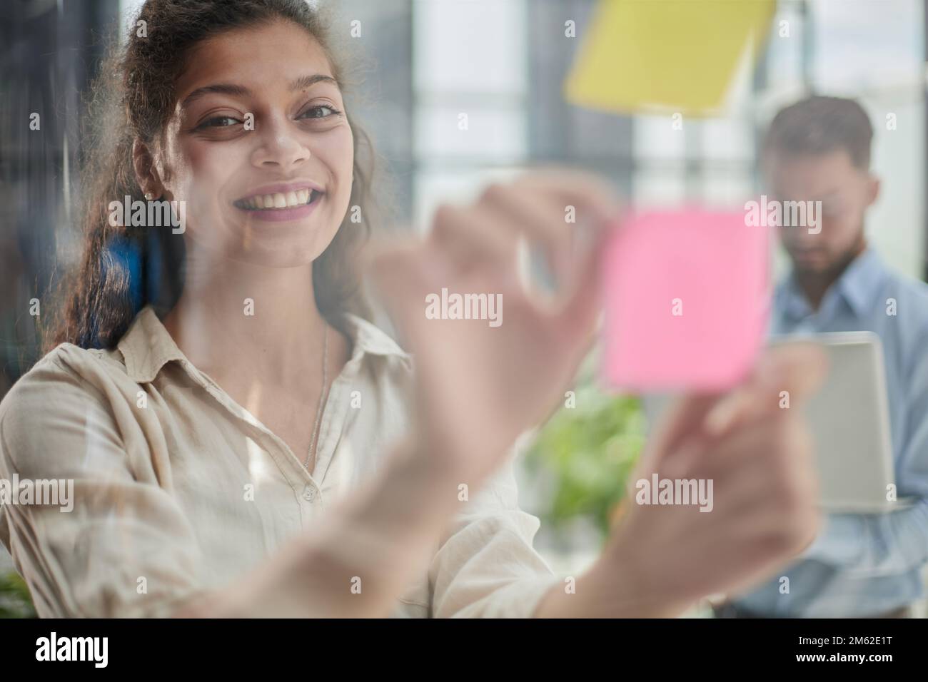 Ihre Vision zum Leben erwecken. Aufnahme einer selbstbewussten Geschäftsfrau, die ihrem Kollegen mit Haftnotizen an einer Glaswand im Büro eine Idee vorstellt. Stockfoto