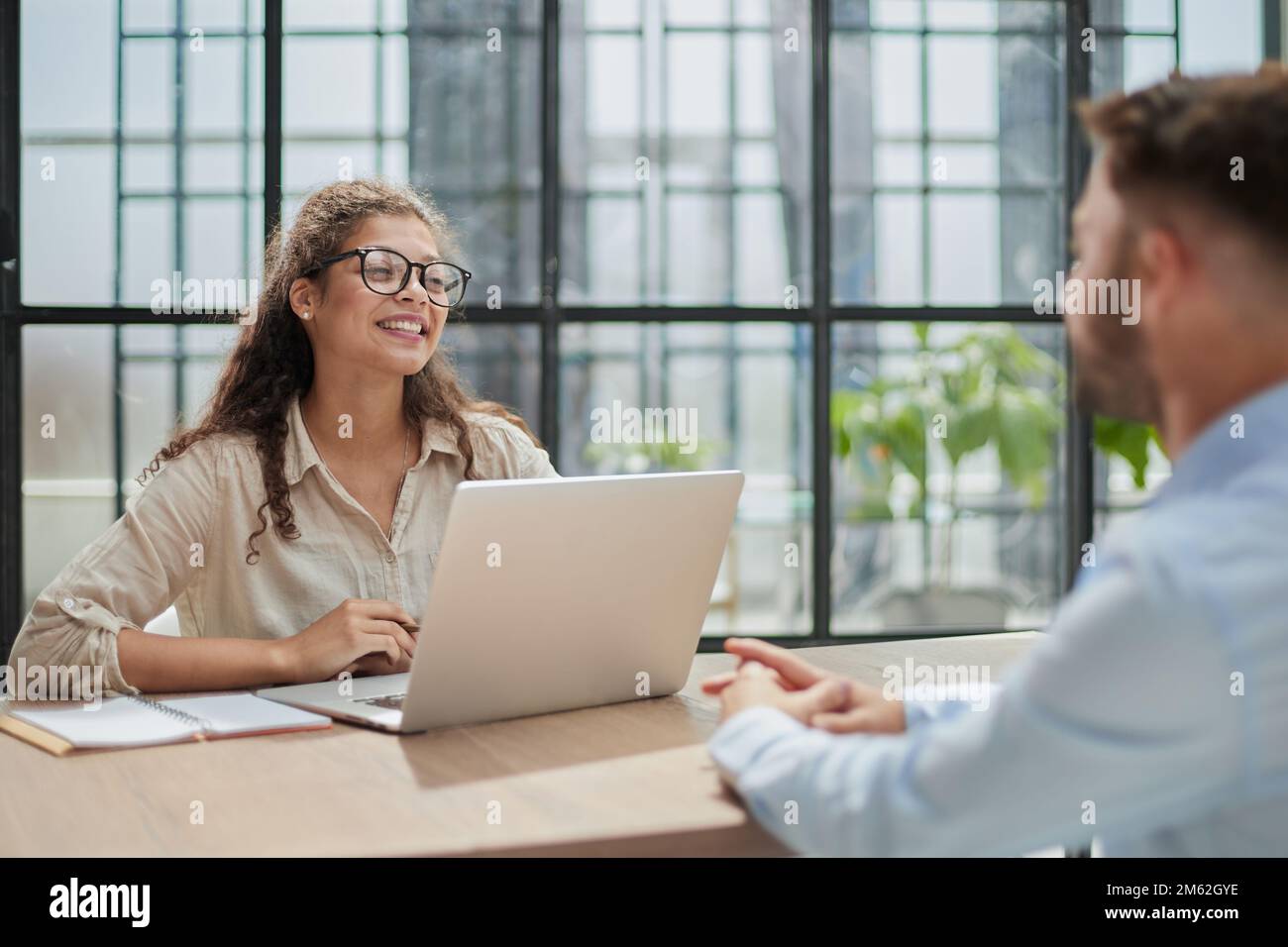 der manager mit Brille, der am Tisch sitzt, empfängt einen Kunden im Büro Stockfoto