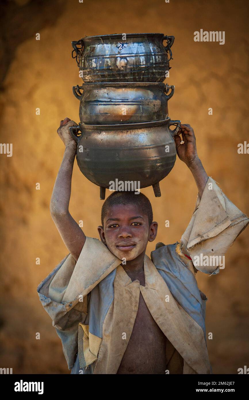 Kleiner Junge mit Töpfen auf seinem Niafunke head.in in Mali, Westafrika. Stockfoto