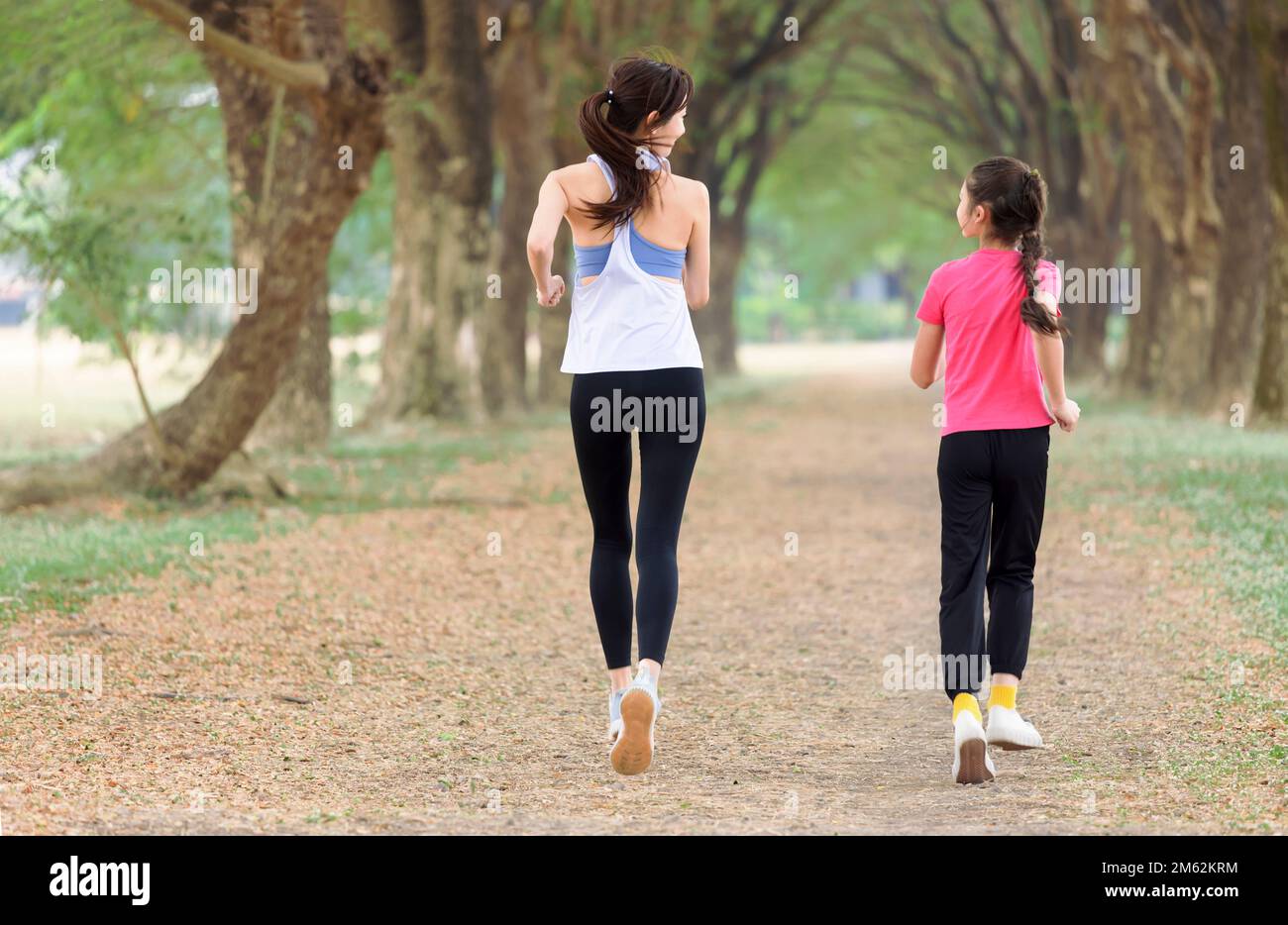 Rückansicht Mutter und Tochter joggen im Park Stockfoto