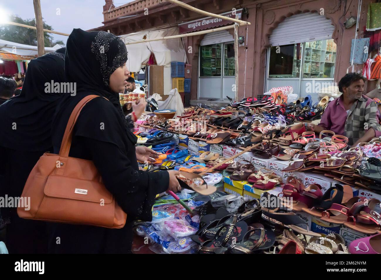 Jodhpur, Rajasthan, Indien - 20.10.2019 : Moderne muslimische Frauen mit Hidschab, Stoff, der Kopf, Hals und Schulter umhüllt, kaufen Schuhe. Stockfoto