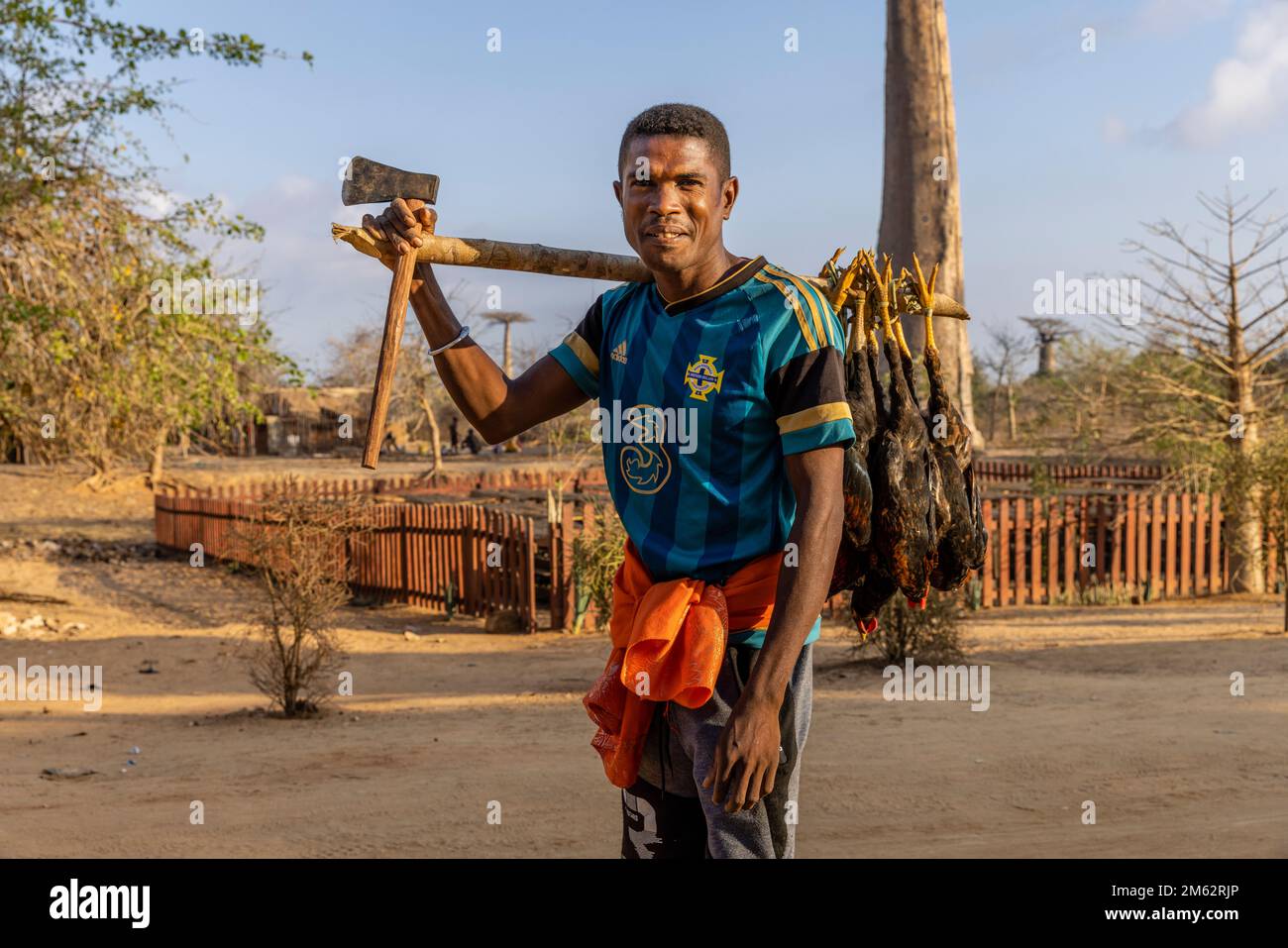 Madagassischer Straßenverkäufer mit Hühnchen und Axt in der Avenue of the Baobabs in Morondava, Madagaskar, Afrika Stockfoto