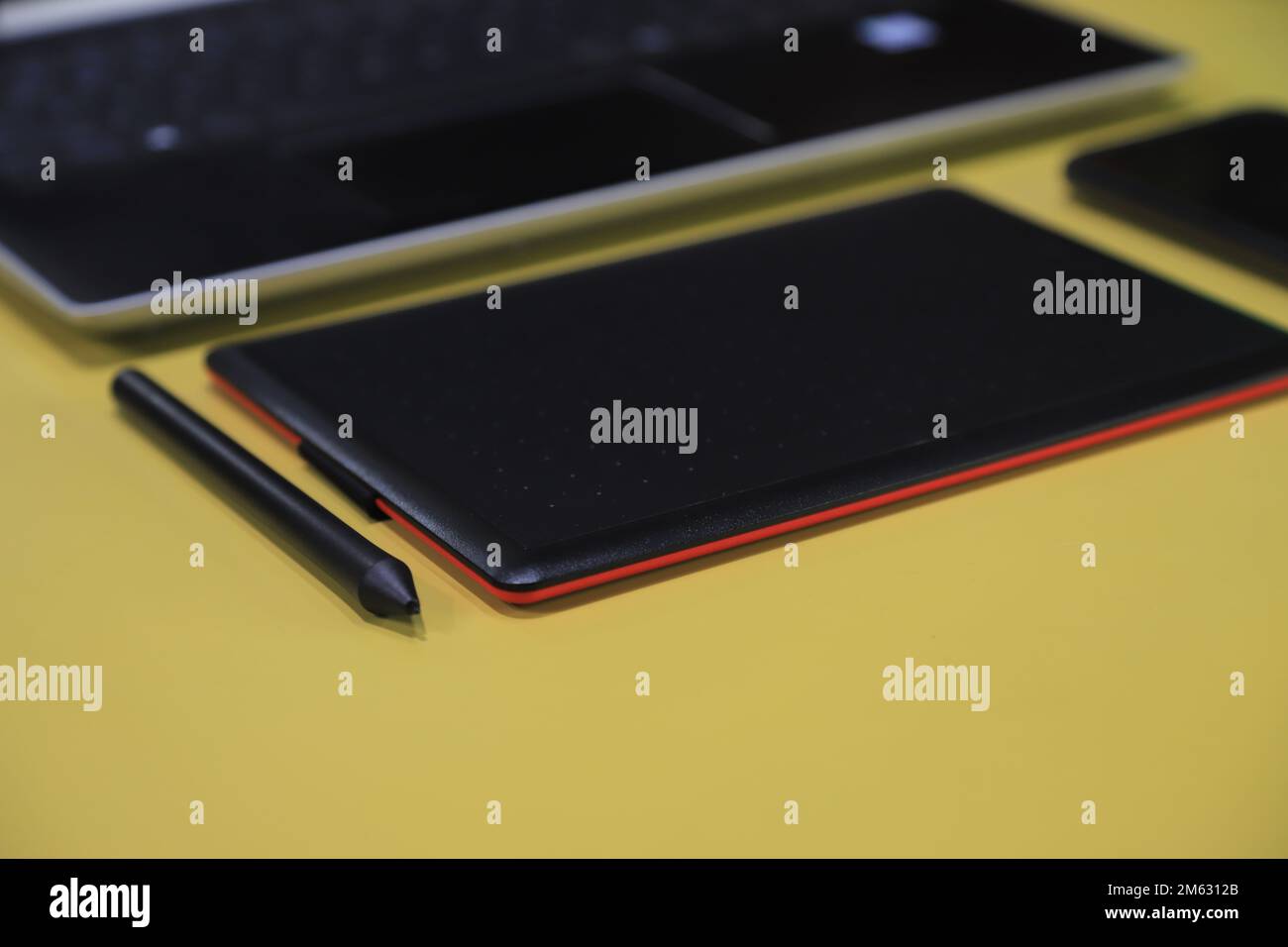 Ein Tablet mit interaktivem Stift und Notebook-Hintergrund Stockfoto