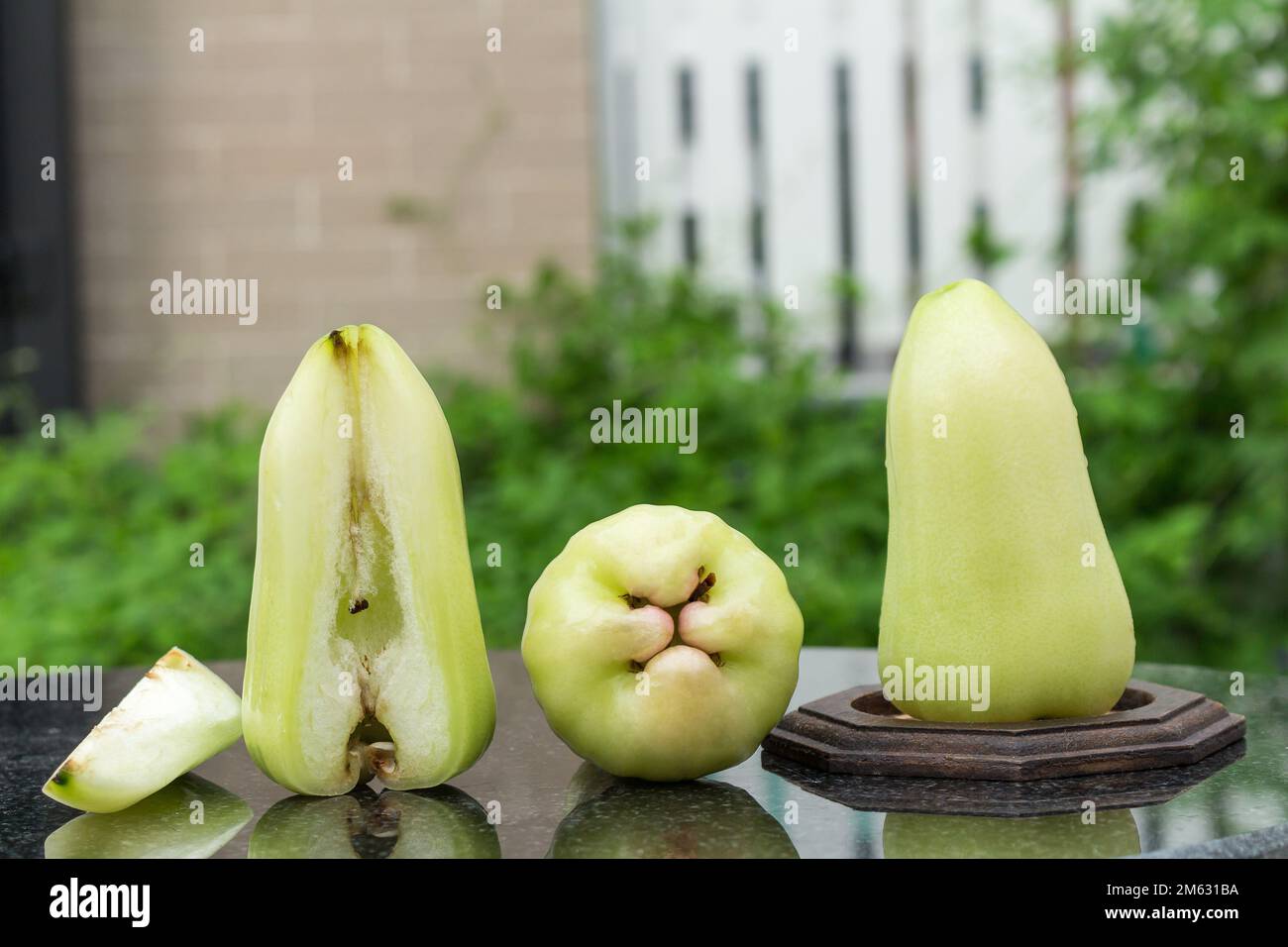 Grüner Rosenapfel auf schwarzem Marmor. Im Freien. Garten. Tag. Stockfoto