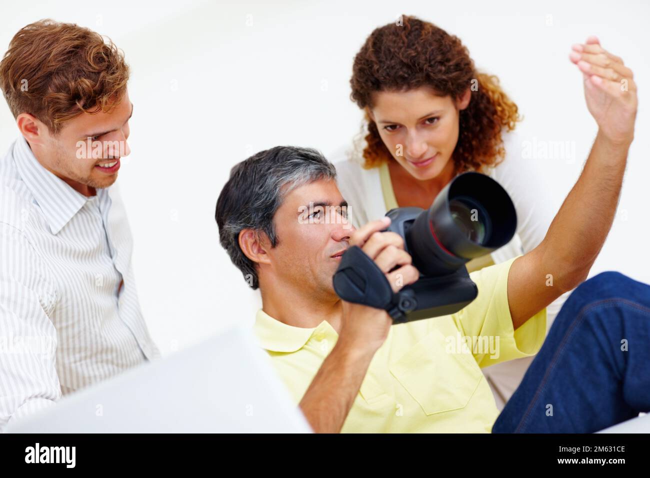 Fotografen, die Fotos in der Kamera auschecken. Fotograf mittleren Alters, der seinen Kollegen Fotos in seiner Kamera zeigt. Stockfoto