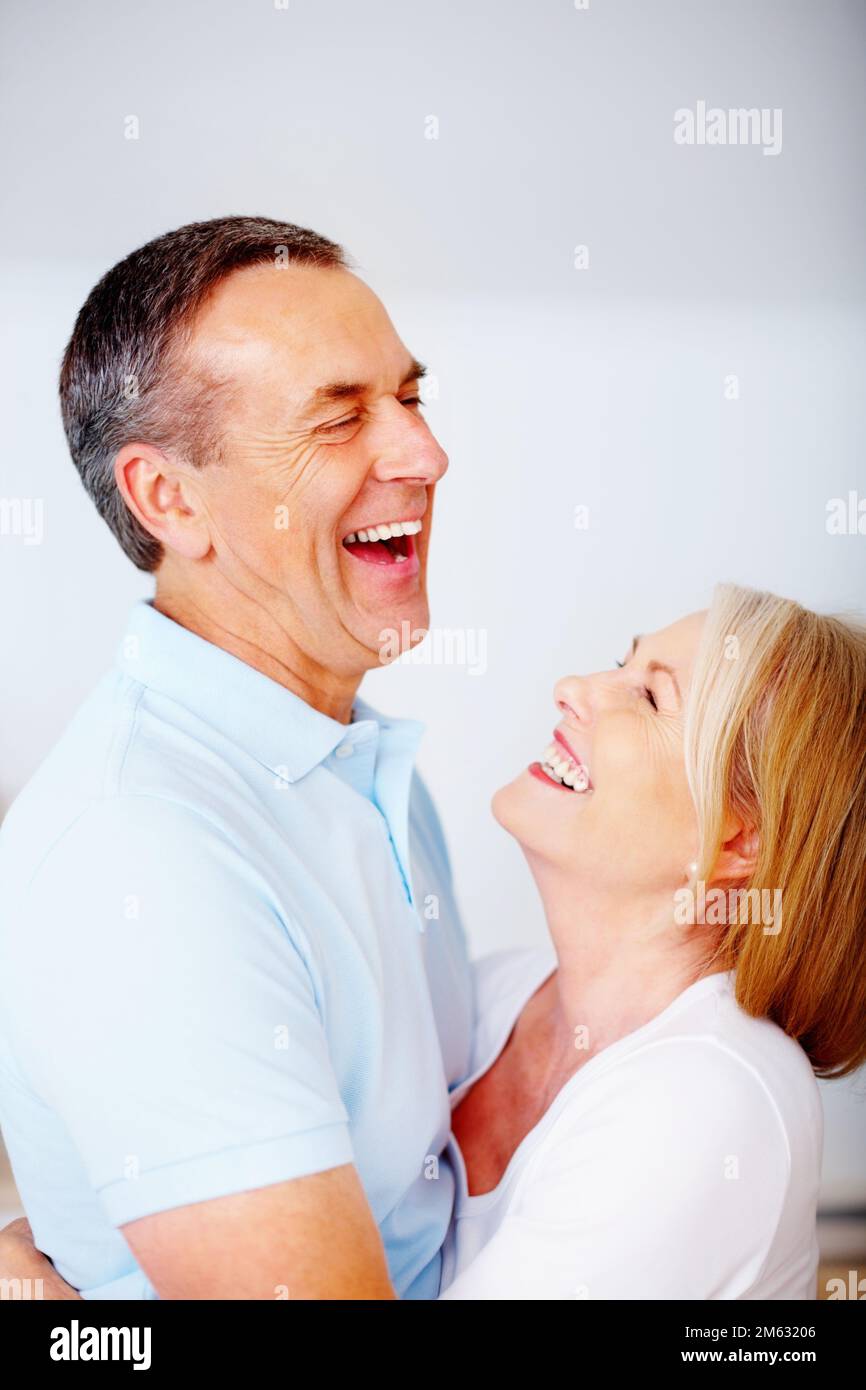 Romantisches Seniorenpaar, das sich vor leerem Hintergrund umarmt. Porträt eines romantischen Seniorenpaares, das sich vor leerem Hintergrund umarmt. Stockfoto