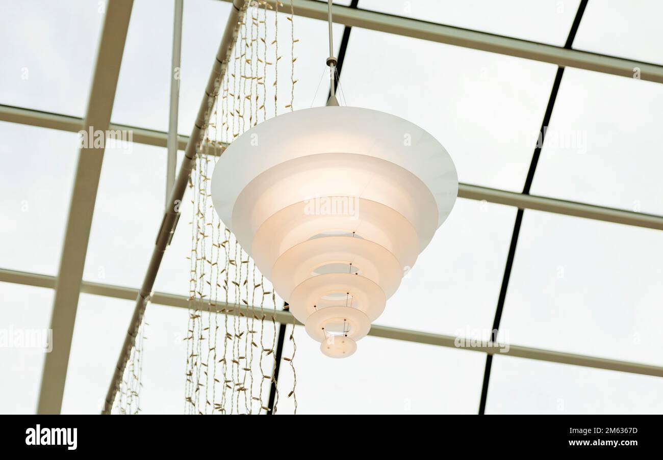 Im finnischen Einkaufszentrum hängt eine große Acryllampe an der Decke Stockfoto