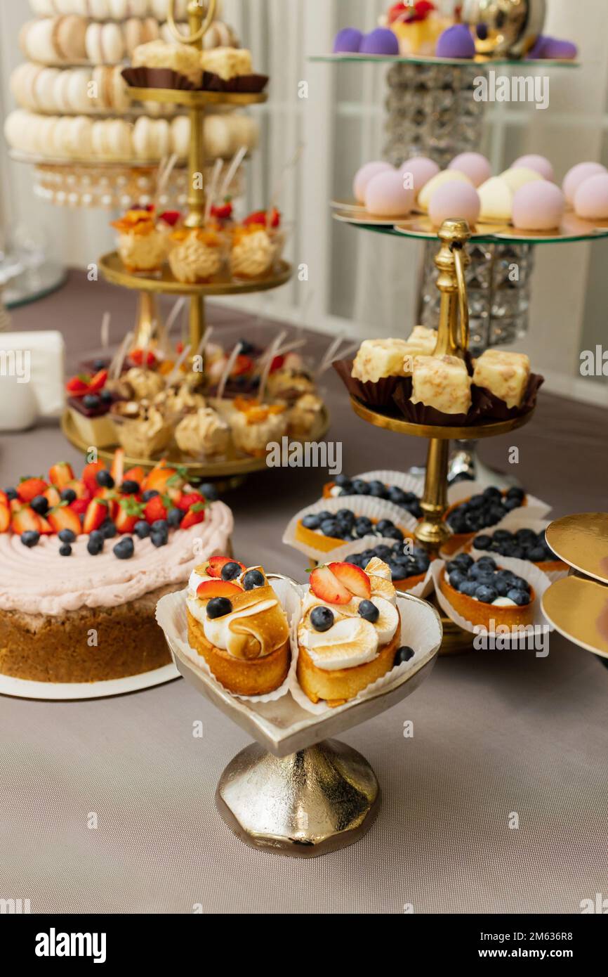 Tisch mit Kuchen, Süßigkeiten, Süßigkeiten, Buffet. Desserttisch für eine Party-Leckereien für den Hochzeitsbankett-Bereich. Süßigkeitenbar aus nächster Nähe Stockfotografie