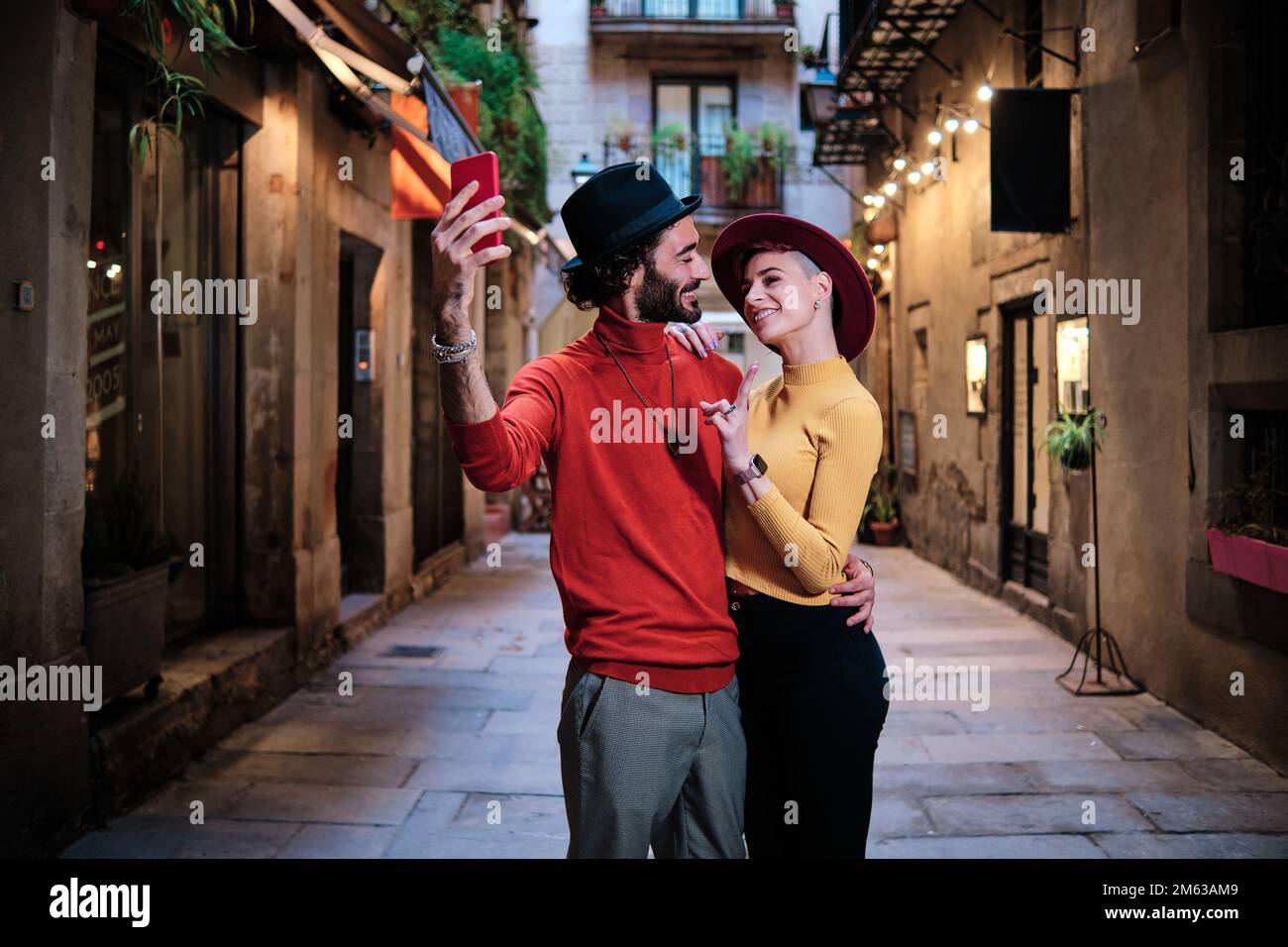 Zärtliches Paar, das sich umarmt, während es ein Selfie im Freien macht Stockfoto