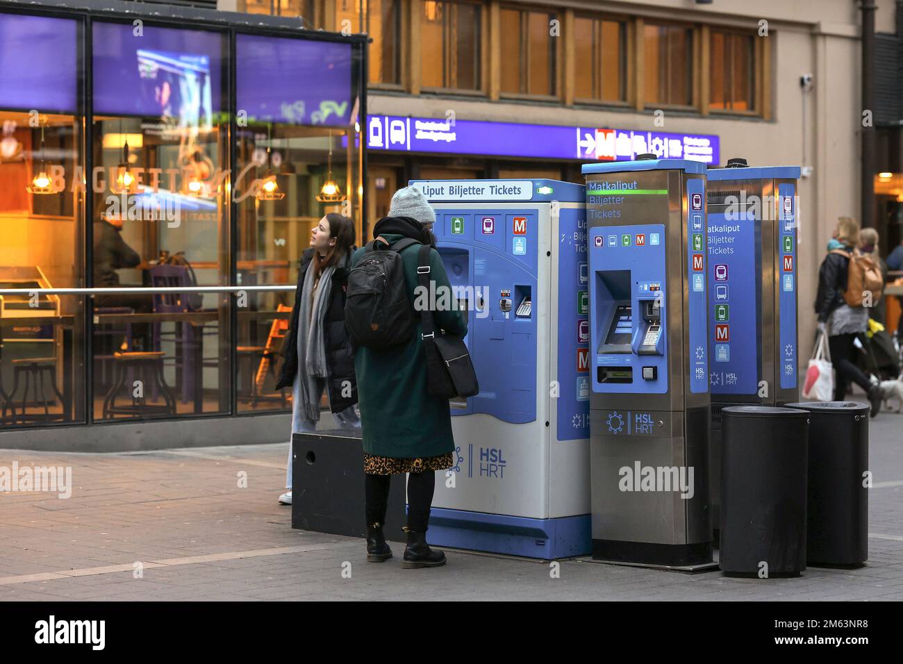 Eine Frau kauft eine Zugfahrkarte an einem Fahrkartenautomaten am Hauptbahnhof Helsinki. Der Hauptbahnhof von Helsinki ist der Hauptbahnhof für Pendlerzüge und Fernzüge ab Helsinki, Finnland. Stockfoto