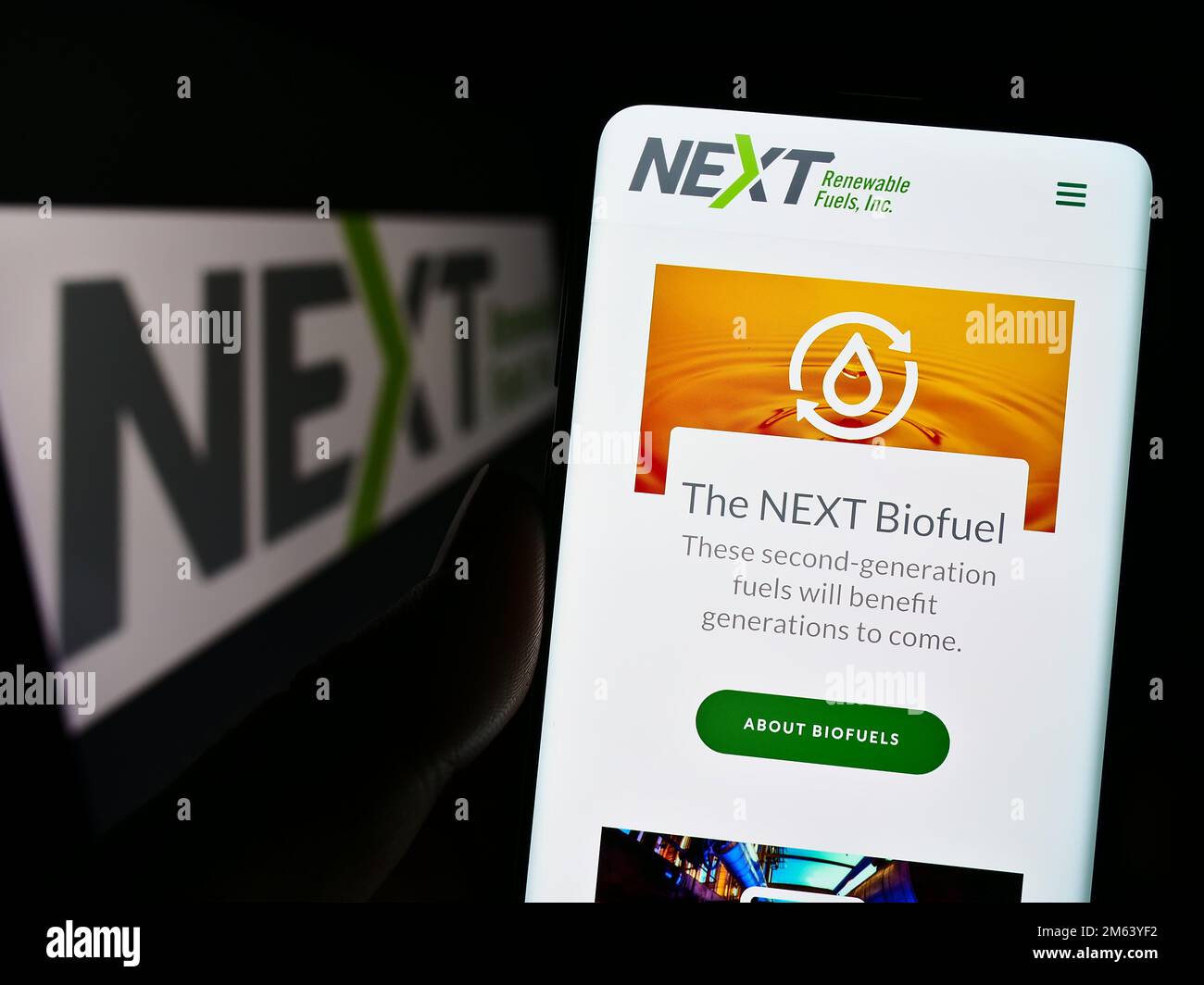 Person, die ein Smartphone mit der Website des US-Unternehmens NEXT Renewable Fuels Inc. Auf dem Bildschirm vor dem Logo hält. Konzentrieren Sie sich auf die Mitte des Telefondisplays. Stockfoto