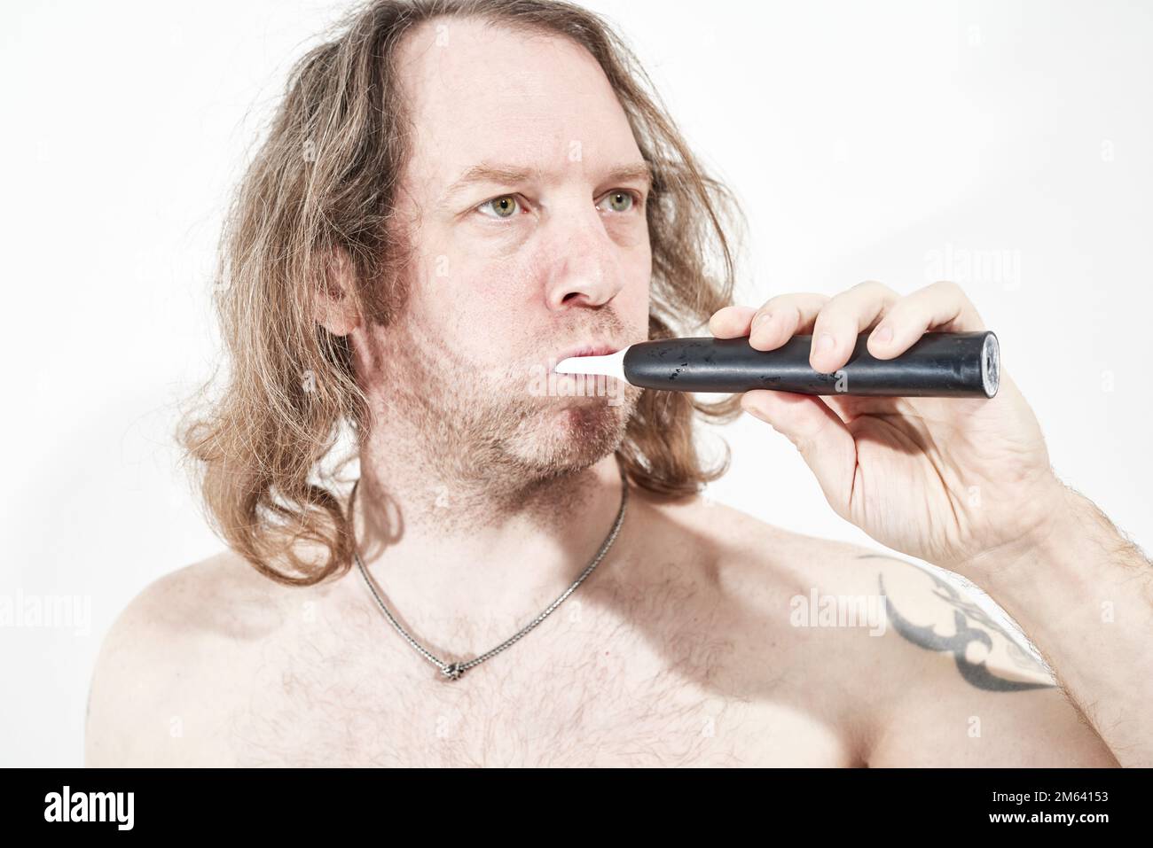 Mann, der Zähne mit einer elektrischen Zahnbürste putzt Stockfoto
