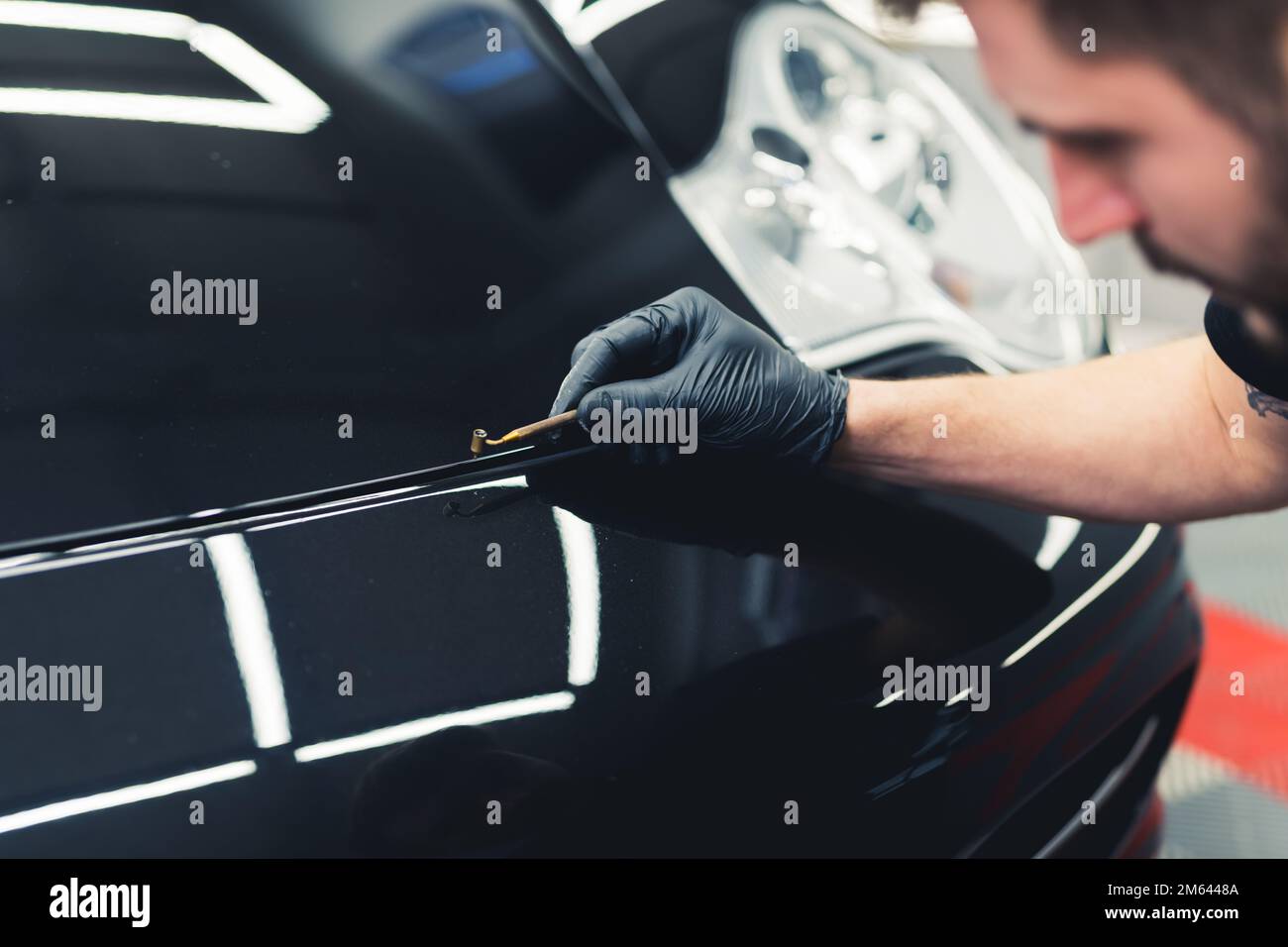 Professionelle Autoverbesserung durch einen Experten für ein schwarzes Luxusfahrzeug. Fahrzeugdetails. Hochwertiges Foto Stockfoto