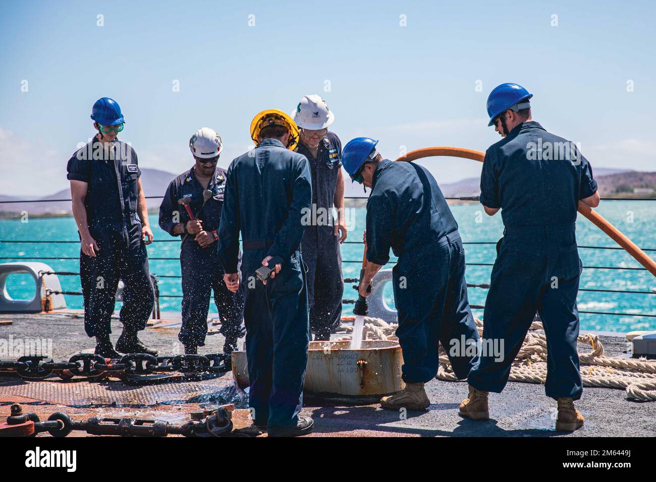 220330-N-GF955-1043 MARINESTÜTZPUNKT GUANTANAMO BAY, KUBA - (30. MÄRZ 2022) - Matrosen, die dem Kampfschiff USS Billings (LCS 15) der Freiheitsvariante zugeteilt sind, saugen die Ankerkette herunter, während sie auf See angehoben wird, und Ankerdetails, wenn das Schiff vom Marinestützpunkt Guantanamo Bay, Kuba, nach einem kurzen Halt für Kraftstoff und Vorräte ablegt, 30. März 2022. Billings wird in das US-Flottengebiet 4. entsandt, um die Mission der Joint Interagency Task Force South zu unterstützen, zu der auch Missionen zur Bekämpfung des illegalen Drogenhandels in der Karibik und im östlichen Pazifik gehören. Stockfoto