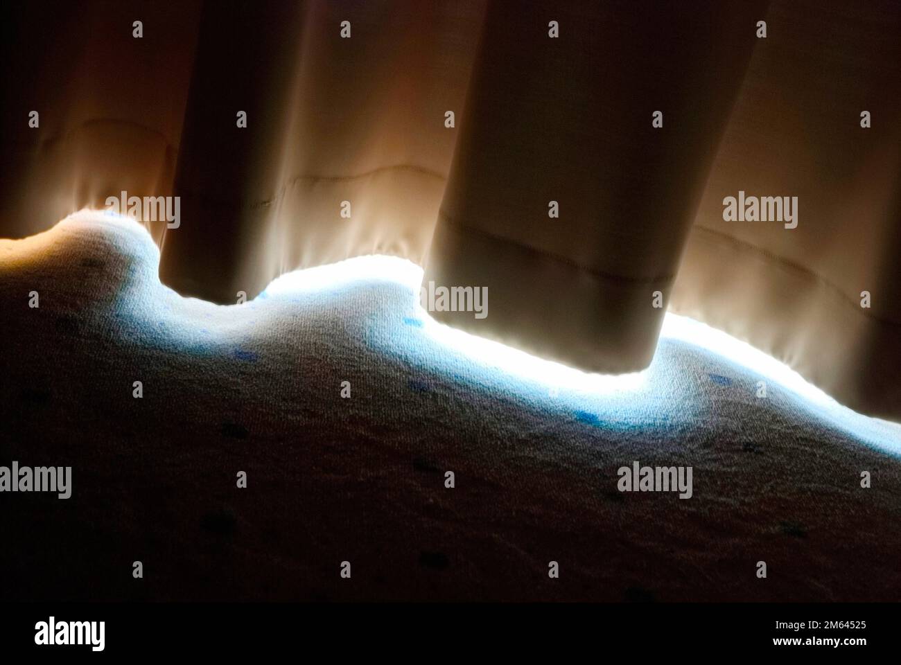 Licht kommt durch einen gezogenen Vorhang Stockfoto