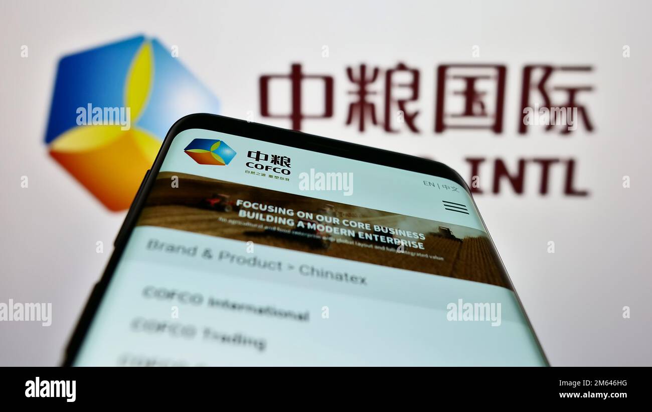 Mobiltelefon mit Webseite der China Oil and Food Corporation (COFCO) auf dem Bildschirm vor dem Logo. Fokus auf oberer linker Seite des Telefondisplays. Stockfoto