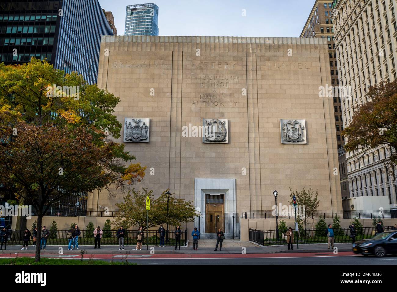 Leute warten auf einen Bus vor dem Brooklyn Battery Tunnel Authority Building, Lower Manhattan, New York City, USA Stockfoto