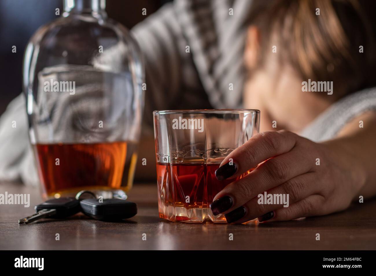 Betrunkene betrunkene Frau, die in der Nähe von WhiskeyGlas schläft, weibliche starke Trinkerin