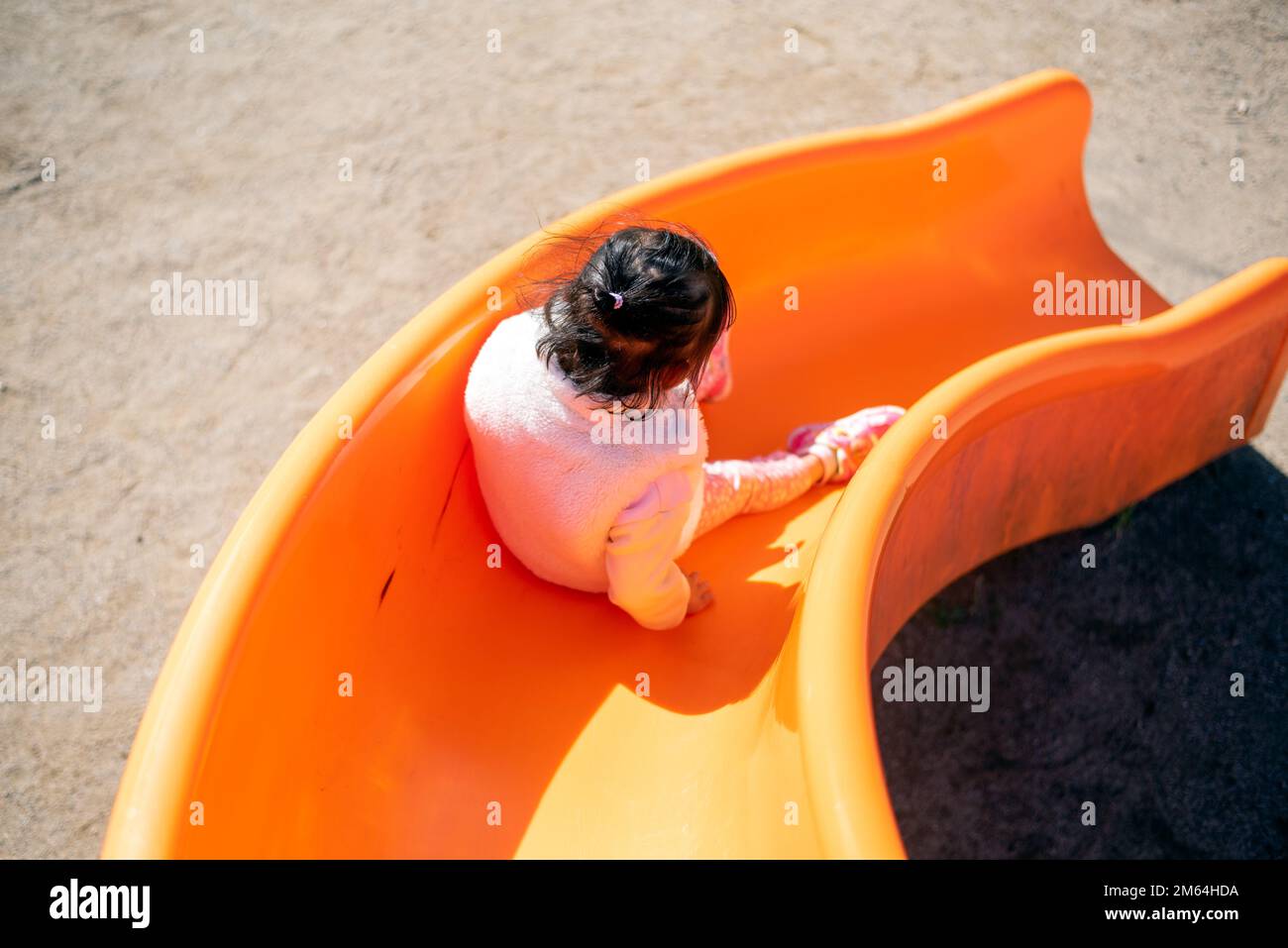 Ein Kind, das auf einer Rutsche auf einem Spielplatz spielt. Stockfoto