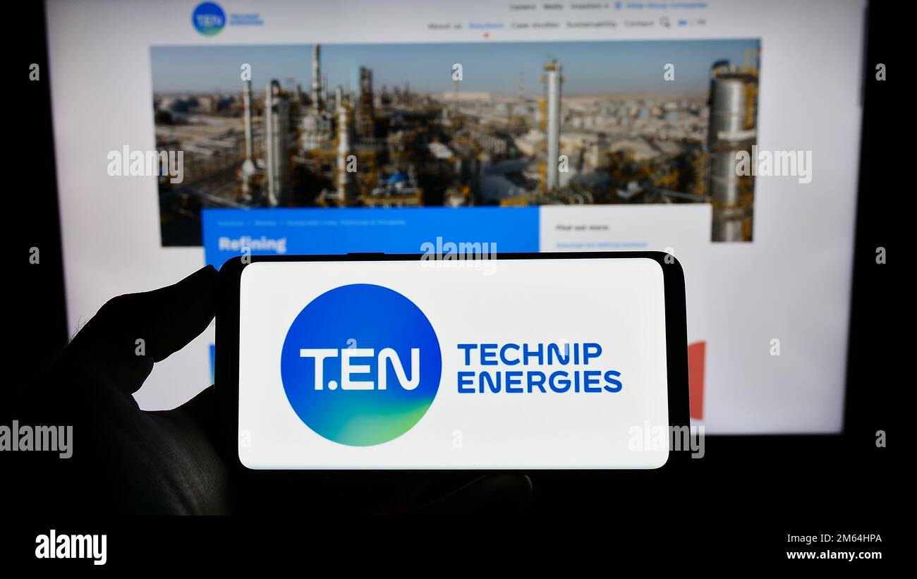 Person, die ein Smartphone mit dem Logo des französischen Ingenieurunternehmens Technip Energies N.V. auf dem Bildschirm vor der Website hält. Konzentrieren Sie sich auf das Display des Telefons. Stockfoto