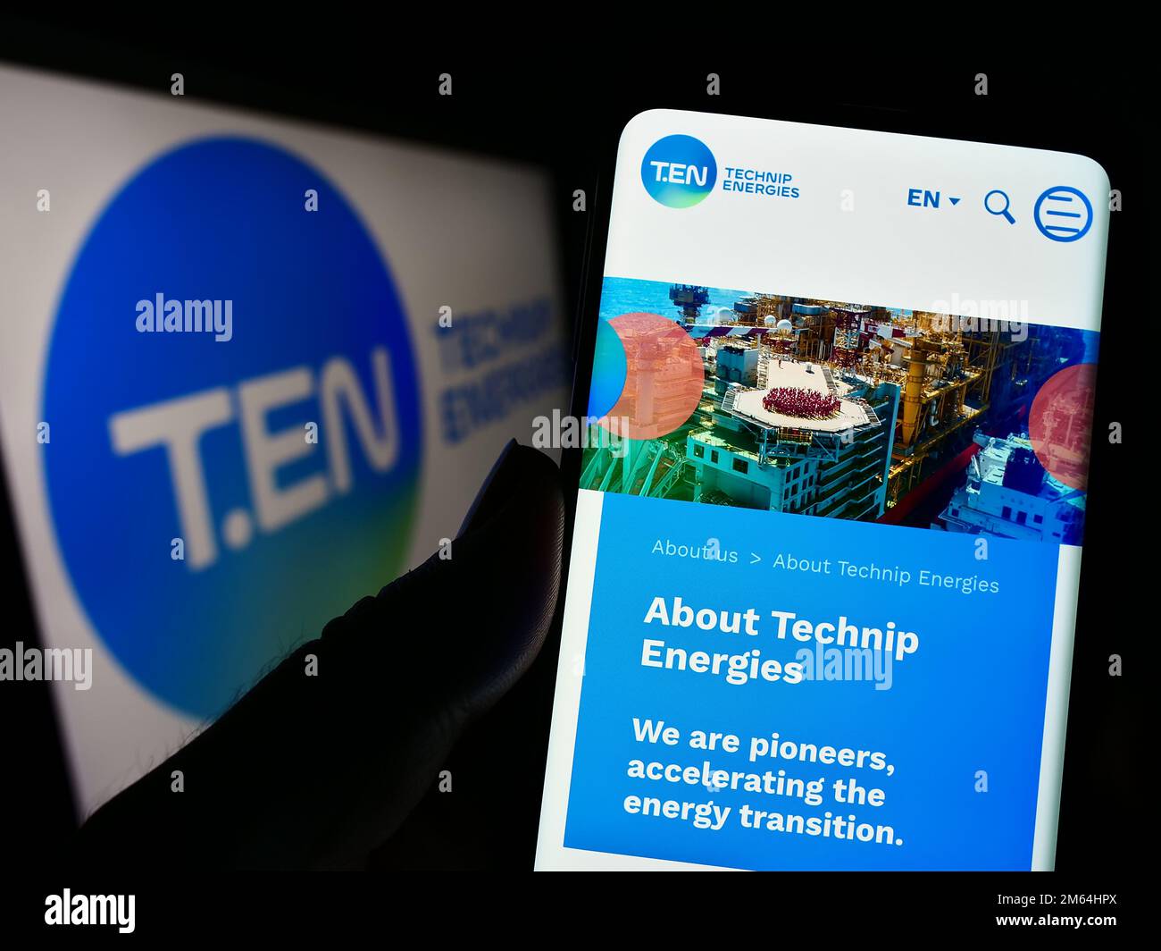 Person, die ein Mobiltelefon mit einer Website des französischen Ingenieurunternehmens Technip Energies N.V. auf dem Bildschirm mit Logo hält. Konzentrieren Sie sich auf die Mitte des Telefondisplays. Stockfoto