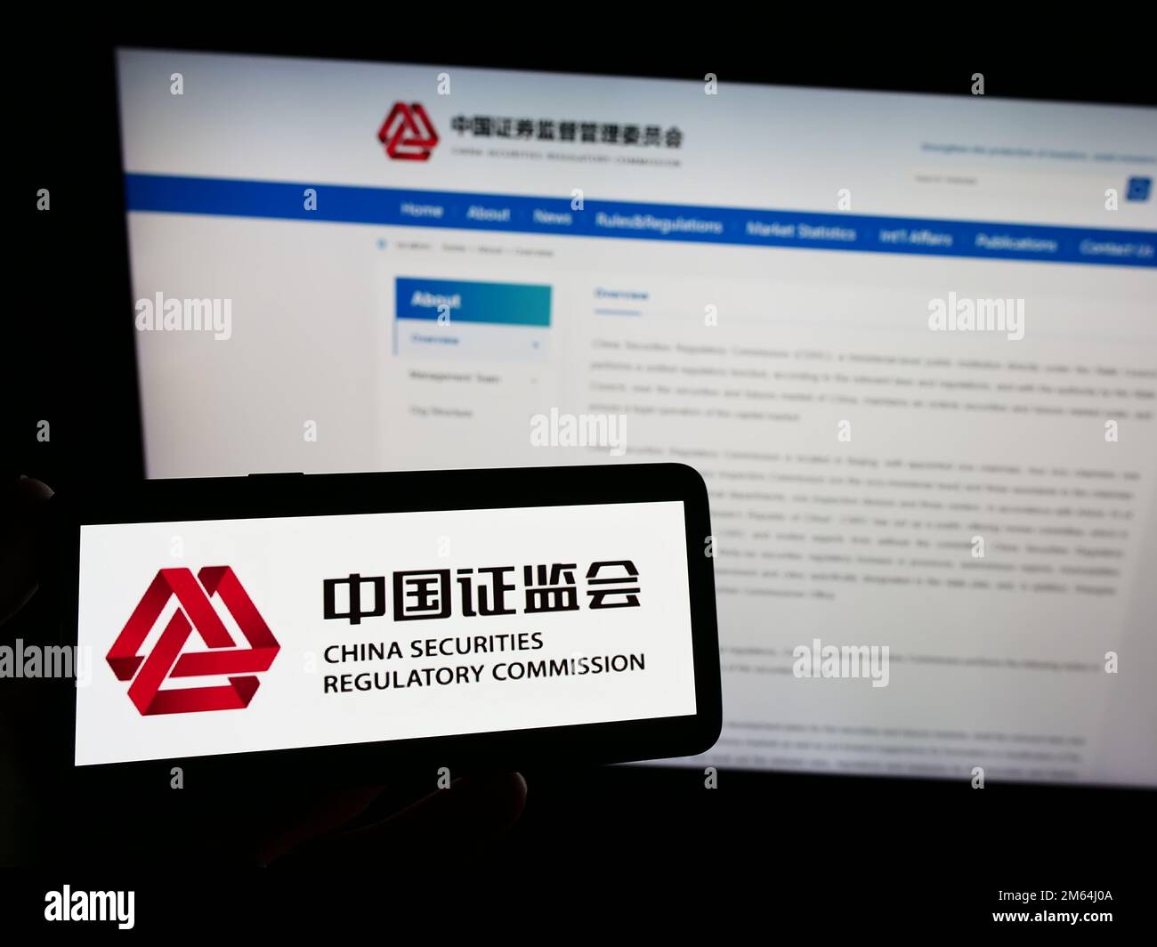 Person, die ein Smartphone mit dem Logo der China Securities Regulatory Commission (CSRC) auf dem Bildschirm vor der Website hält. Konzentrieren Sie sich auf das Display des Telefons. Stockfoto