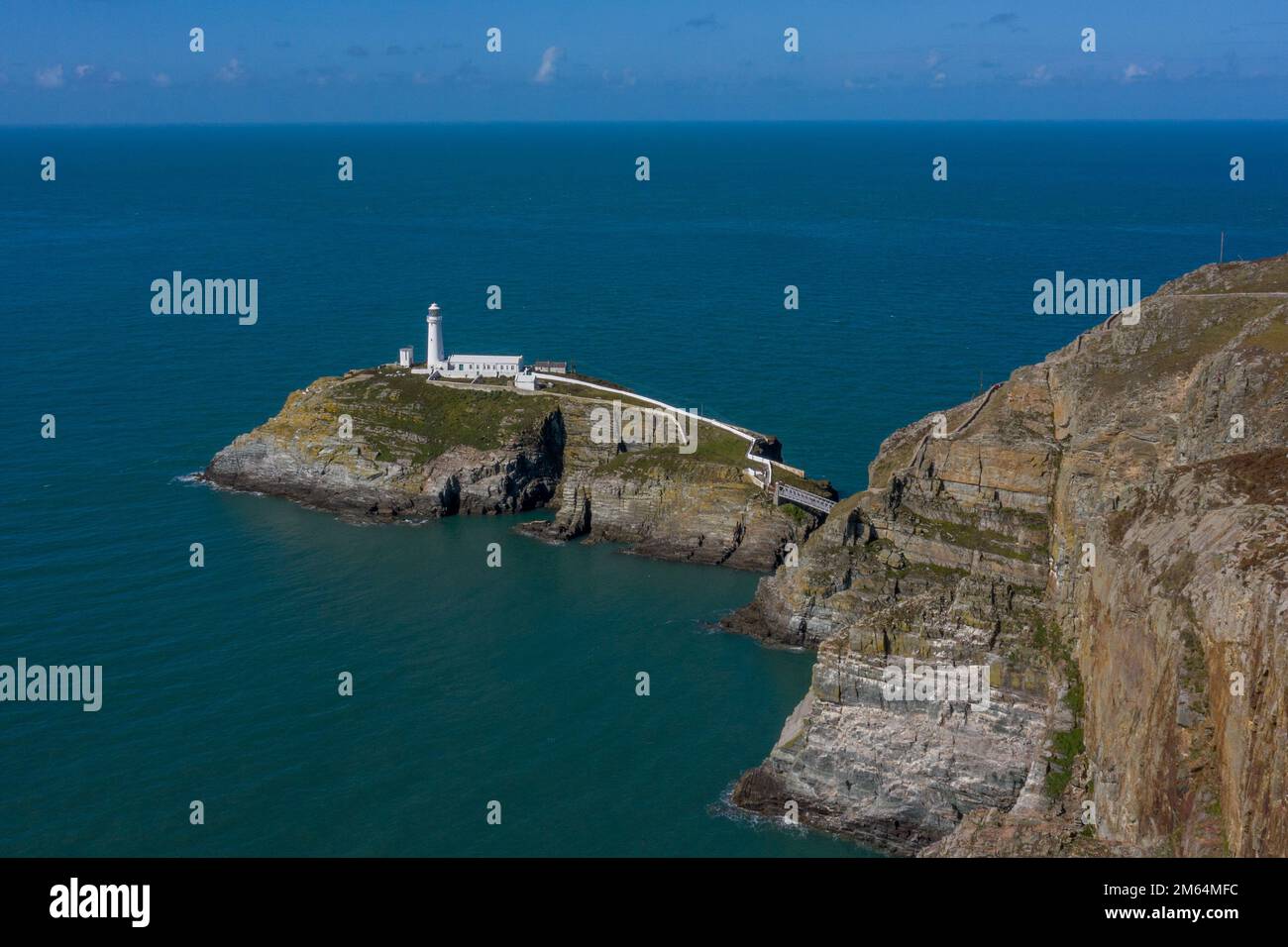 Panoramafoto des South Stack Lighthouse in der Nähe der Holyhead Anglesey Luftaufnahme vom Meer aus mit Blick auf die Insel und die felsigen Klippen Stockfoto