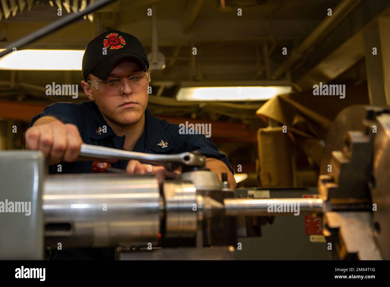 Maschinenreparateur 2., Klasse Bowen Kincaid, aus Battle Creek, Michigan, der der technischen Abteilung von USS Gerald R. Ford (CVN 78) zugeteilt ist, bereitet eine Drehmaschine für den Einsatz in der Maschinenwerkstatt vor, 1. April 2022. Ford führt im Atlantik im Rahmen der auf das Schiff zugeschnittenen Grundphase vor dem Einsatz die Zertifizierung von Cockpits und die Qualifizierung von Flugzeugflügelfluggesellschaften durch. Stockfoto