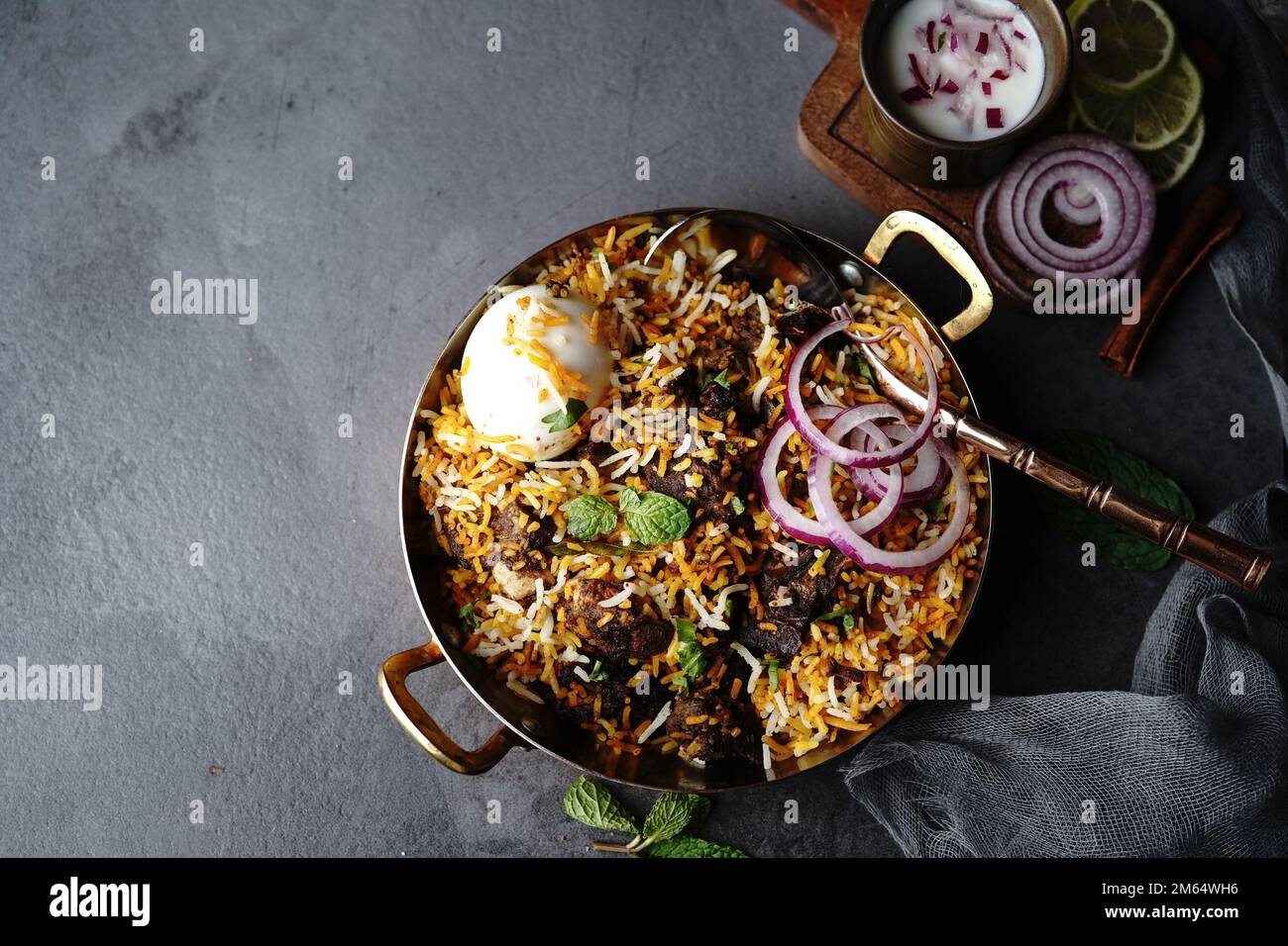 Hausgemachter Ziegenbraten-Biryani | Mutton dum Biryani serviert mit Joghurt-Rita, selektiv im Fokus Stockfoto