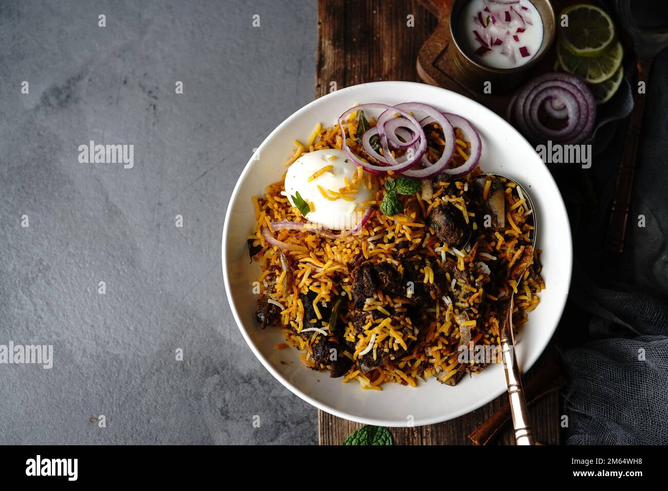 Hausgemachter Ziegenbraten-Biryani | Mutton dum Biryani serviert mit Joghurt-Rita, selektiv im Fokus Stockfoto