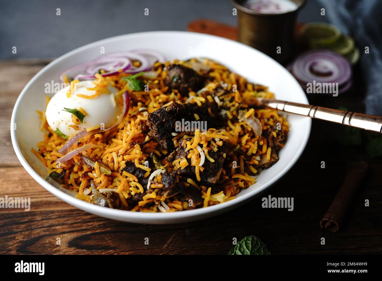 Hausgemachter Ziegenbraten-Biryani | Mutton dum Biryani serviert mit Joghurt-Rita, selektiv im Fokus Stockfoto