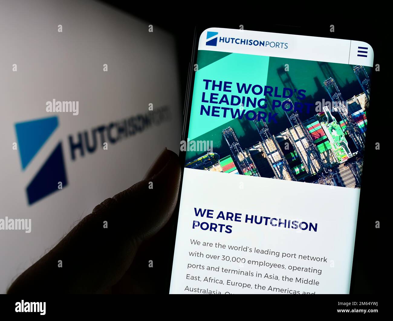 Person mit Smartphone und Website des Unternehmens Hutchison Port Holdings Limited auf dem Bildschirm vor dem Logo. Konzentrieren Sie sich auf die Mitte des Telefondisplays. Stockfoto